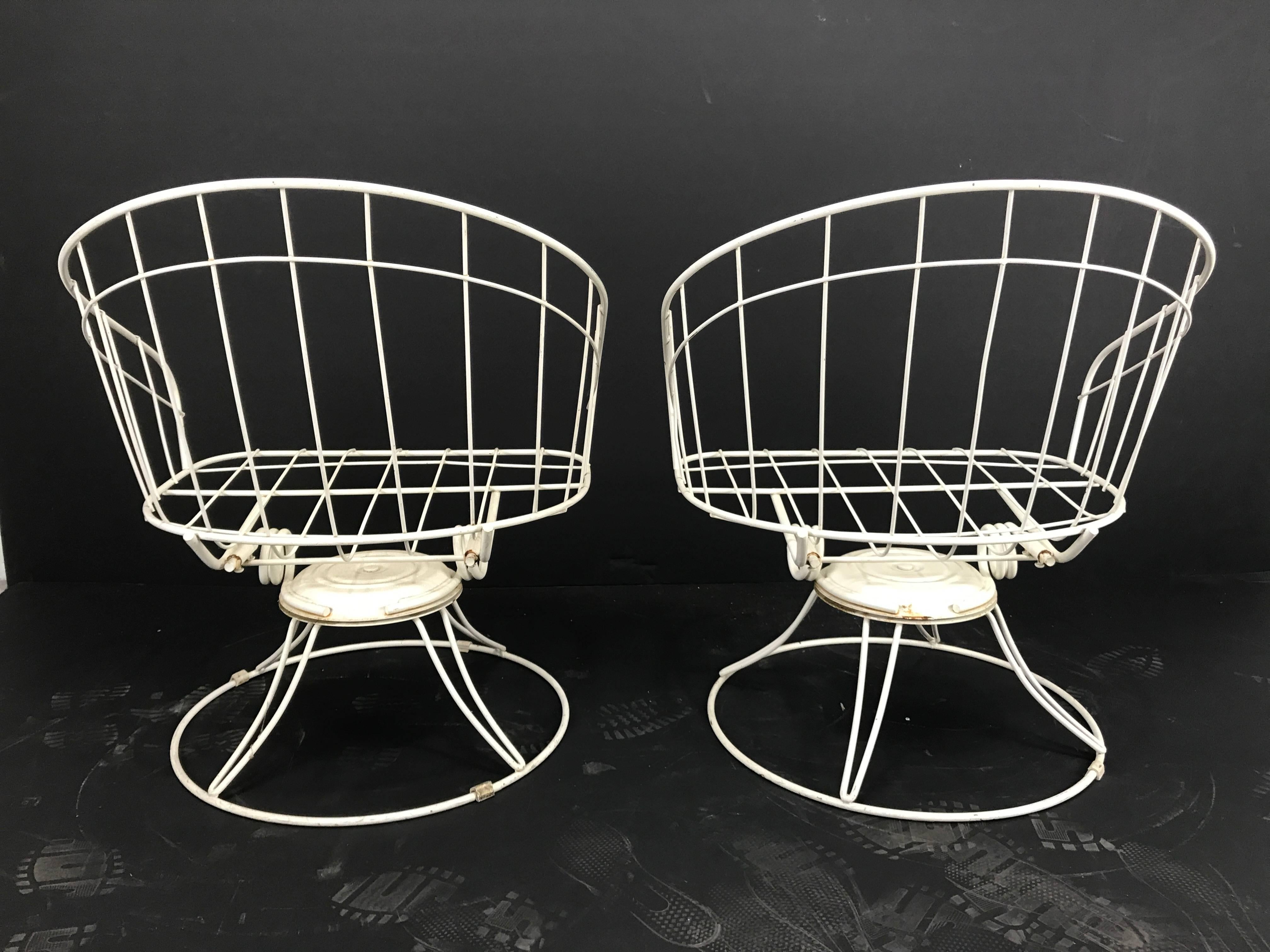 Pair of Mid-Century Modern iron tilt swivel barrel garden chairs, manufactured by Homecrest Furniture. Classic modernist design. Two of a large group of eight pieces being offered,(see other listings) Original replacement cushions available online,