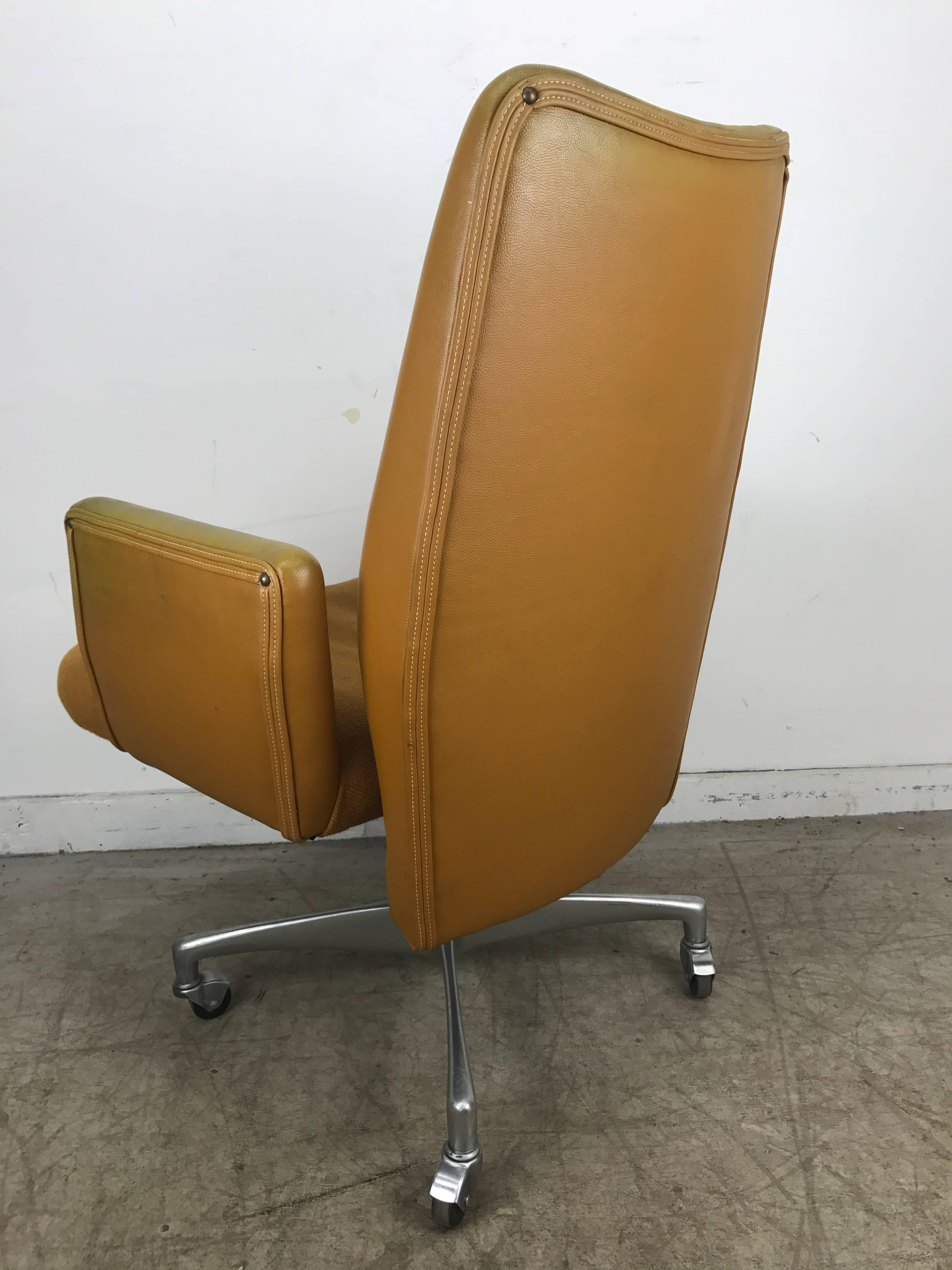 Unusual 1960s modernist executive oversized desk chair. Fully adjustable height. Tilt, swivel, wonderful cast aluminium base on castors, retains original mustard gold naugahyde shell with wool fabric seat, extremely comfortable. Hand delivery avail