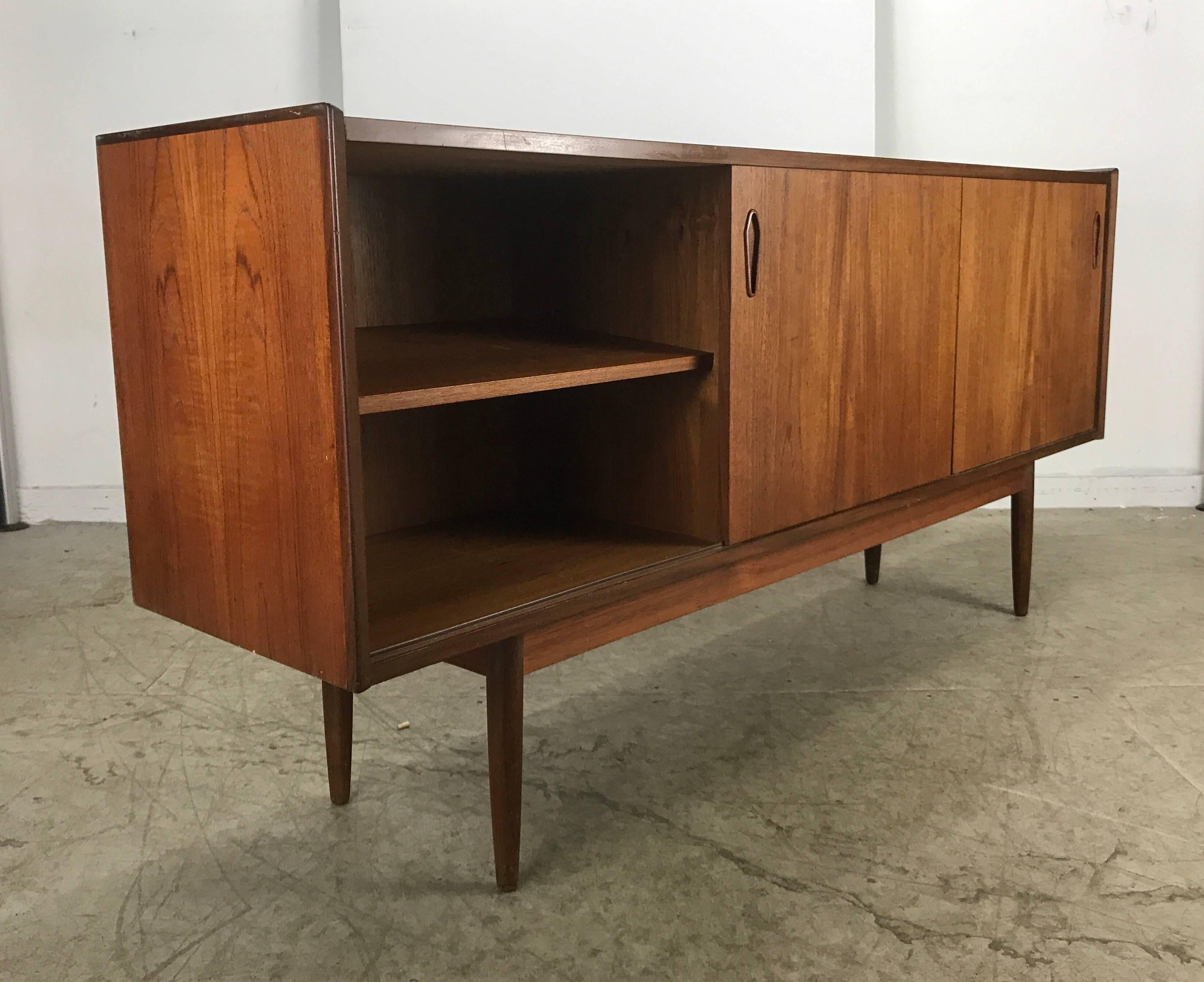 Classic Danish modern credenza/sideboard, figured walnut, stunning rosewood trim detail. Attributed to Arne Vodder. Left and right sliding doors, shelves, unusual coffin shape finger pulls, five drawers birch interior, superior quality and