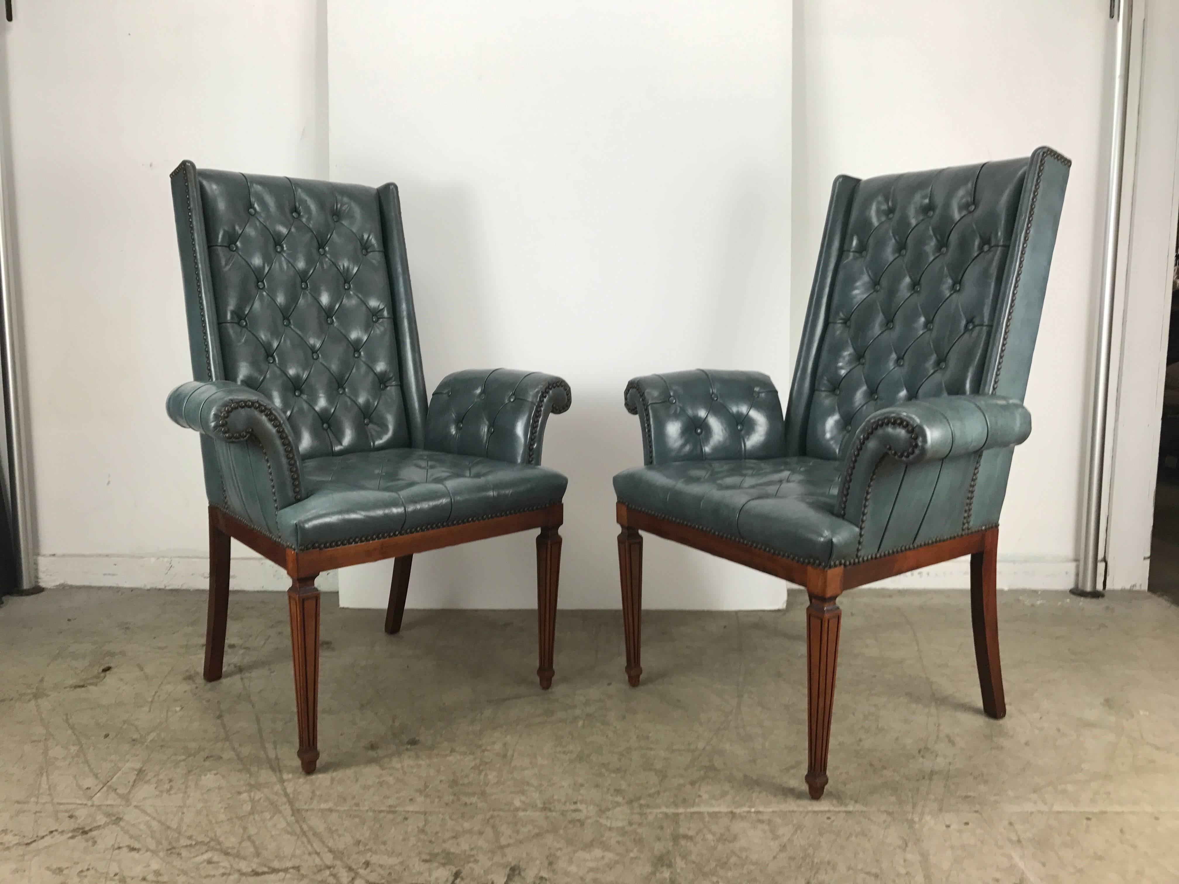 Stunning blue leather button tufted Regency armchairs, attributed to Tommi Parzinger, truly amazing design and color, graceful rolled arms, high winged tufted back. Superior quality and construction, extremely comfortable, 25 inch arm height from
