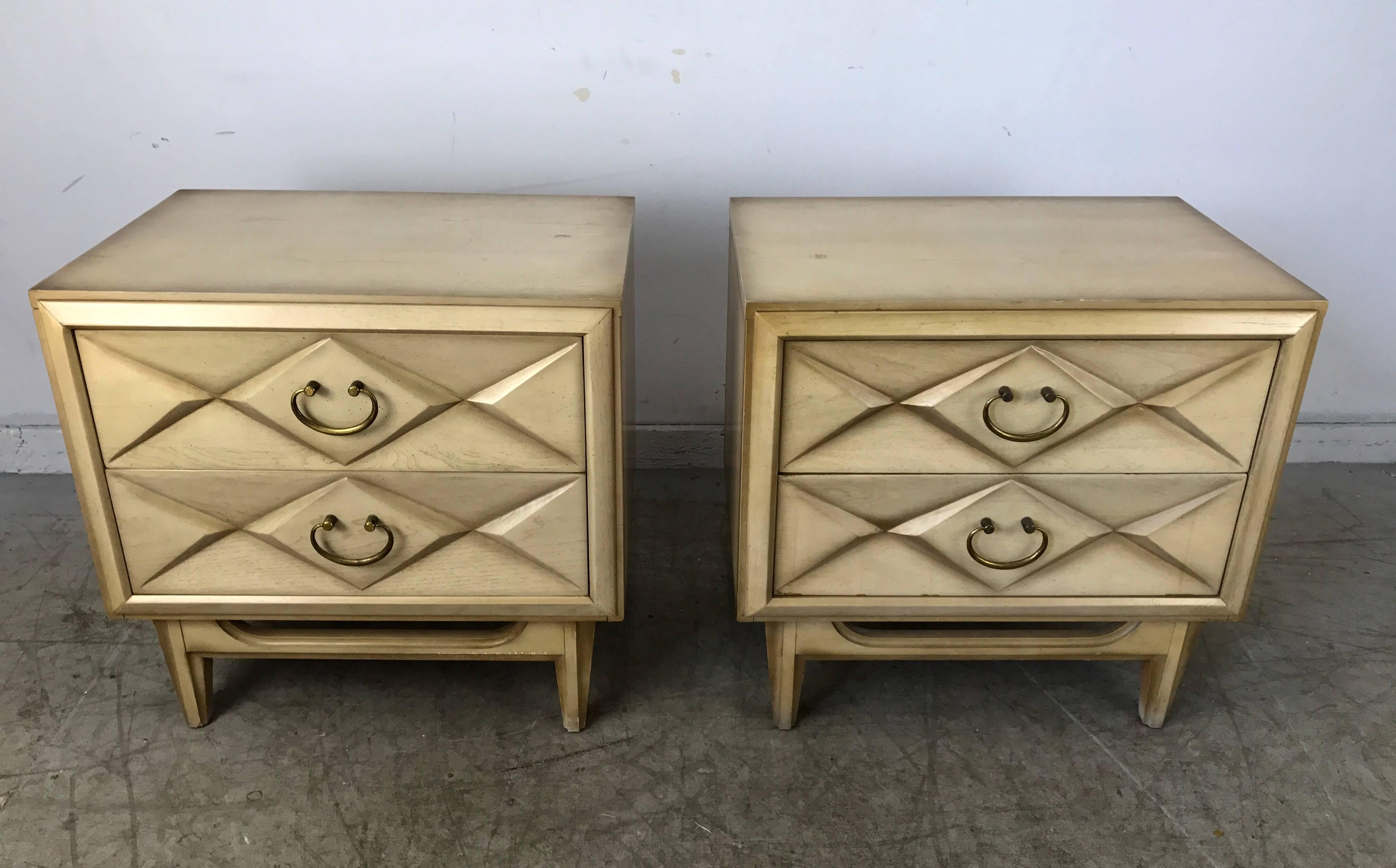 Classic pair of Regency two-drawer nightstands featuring two generous drawers, off-white lacquered wood with gold highlights and brass pulls. Superior quality and construction.