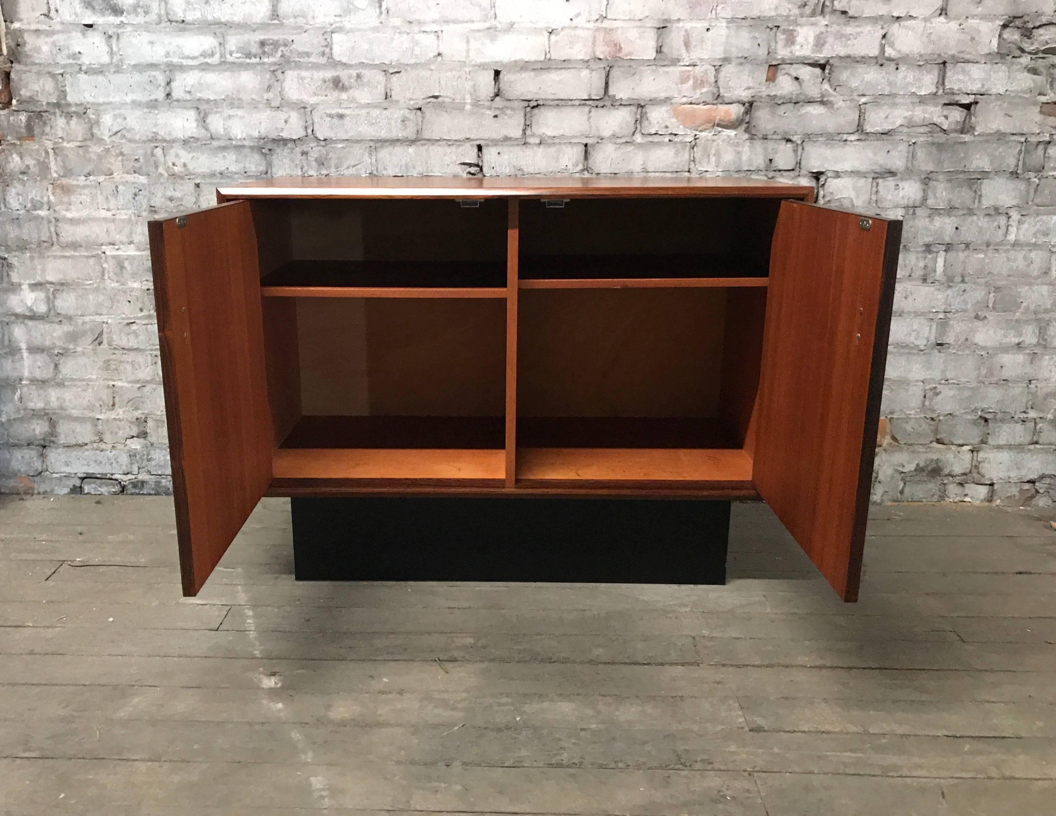 Danish Modern rosewood cabinet in the manner of Poul Hundevad, Stunning, richly grained bookmatched rosewood, black lacquered plinth, chromed detailed hand pulls, two doors and two adjustable shelves, with generous storage, hand delivery available