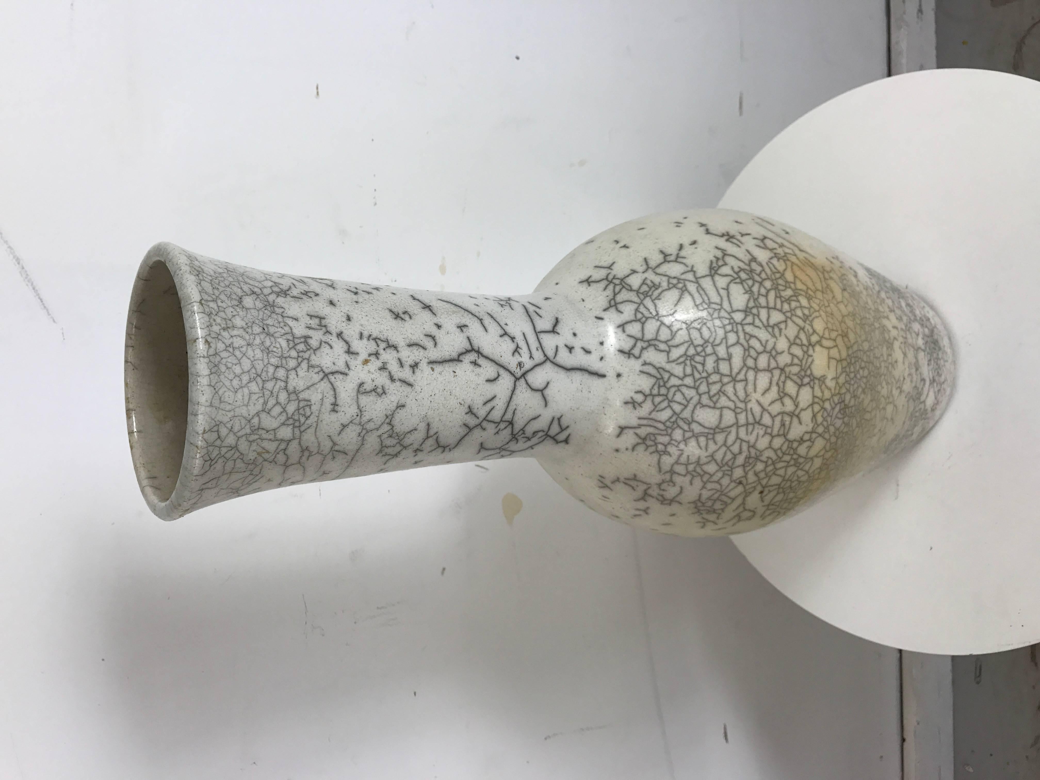 A wonderful example of Nancee Meeker's raku work is found in this large vessel. The primarily white glazed surface, with subtle nuances of cream and grey is complimented by the grey crackling that appears in an unstructured manner around the