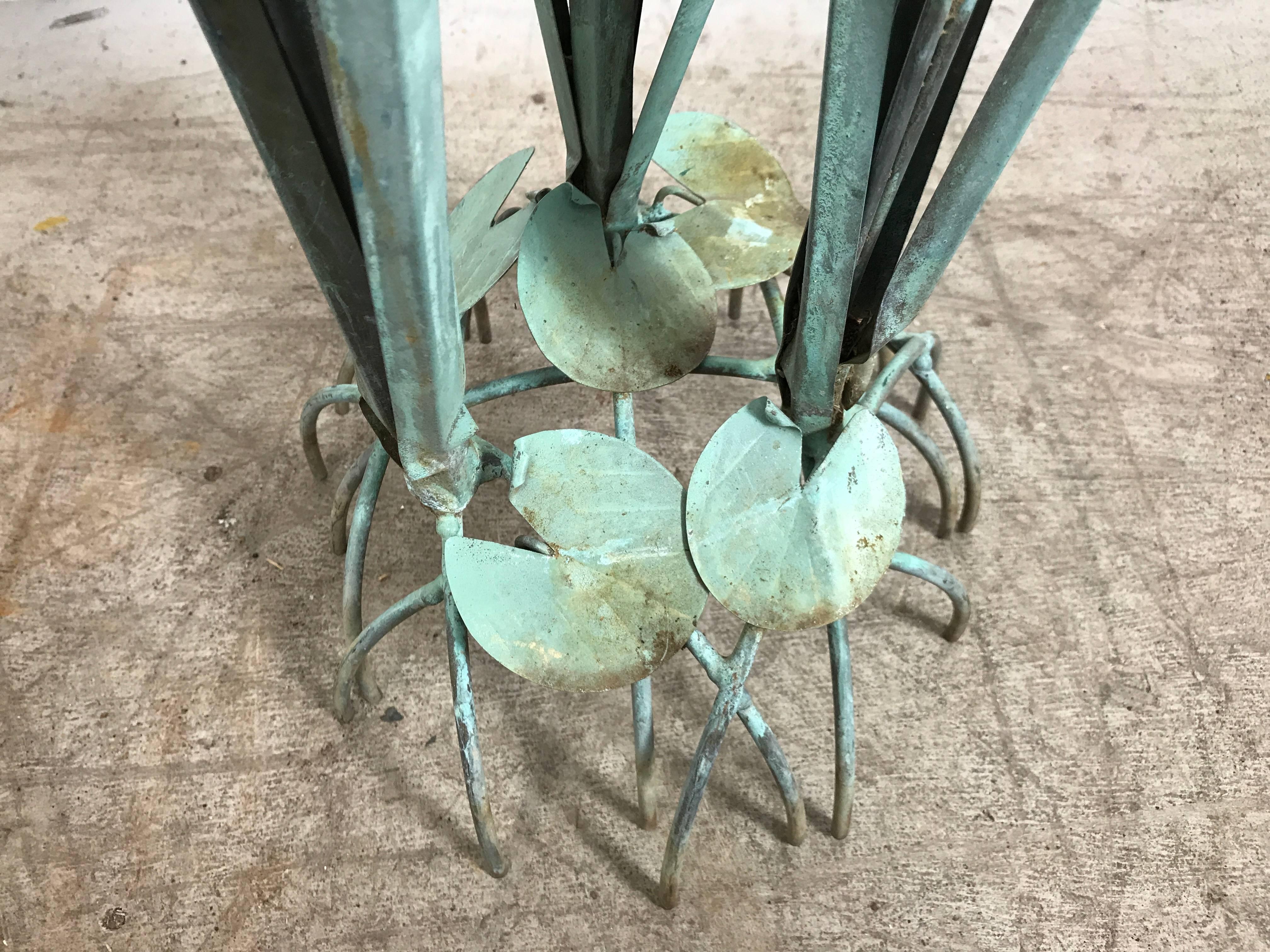 Graceful cattail sculpture. Solid copper cattails shoot upward from oxidized brass leaves. They are surrounded at the base with a cluster of hand formed lily pads. Max Howard studios.