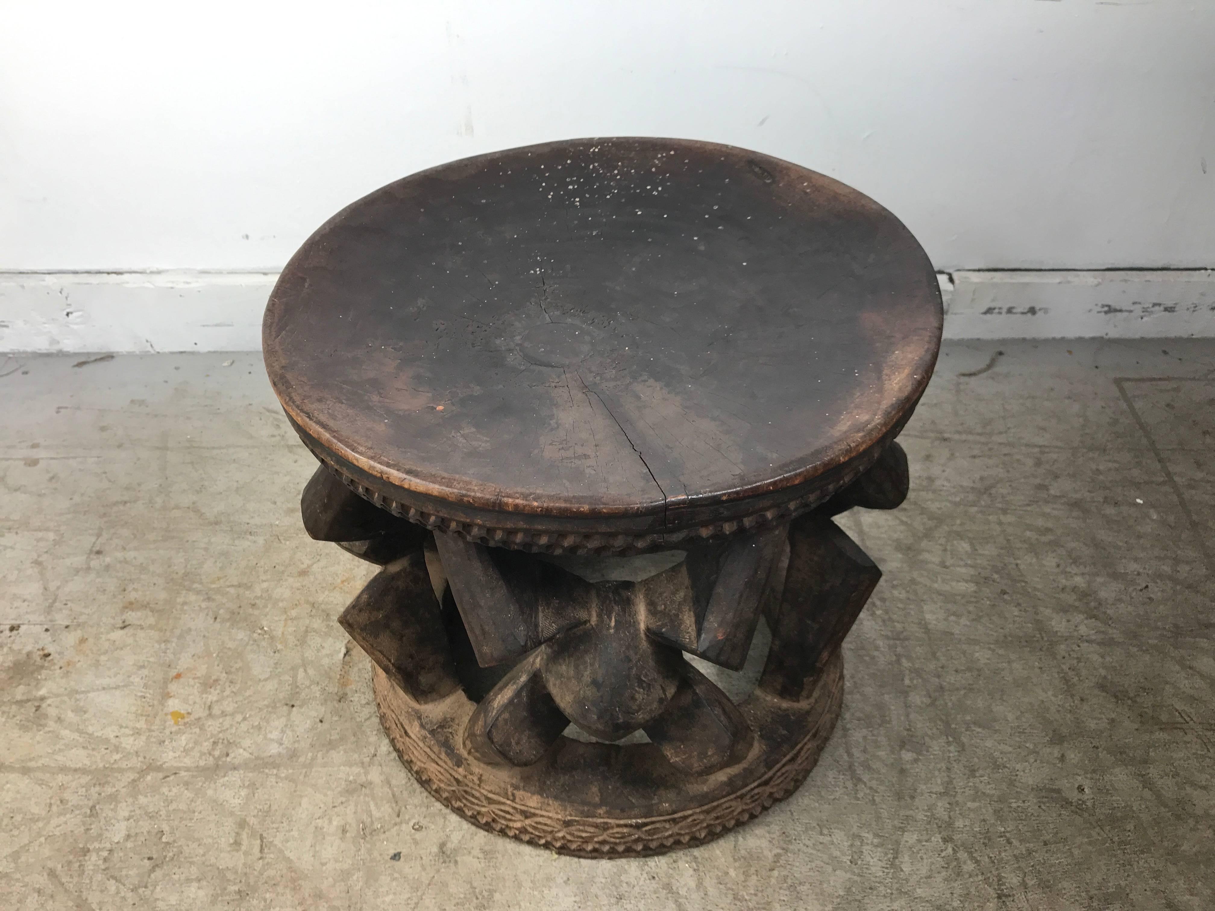 African carved wood stool from Ghana, circa 1920s-1930s, very unusual form, twisted knot design on flat wood base, carving details to top and bottom.