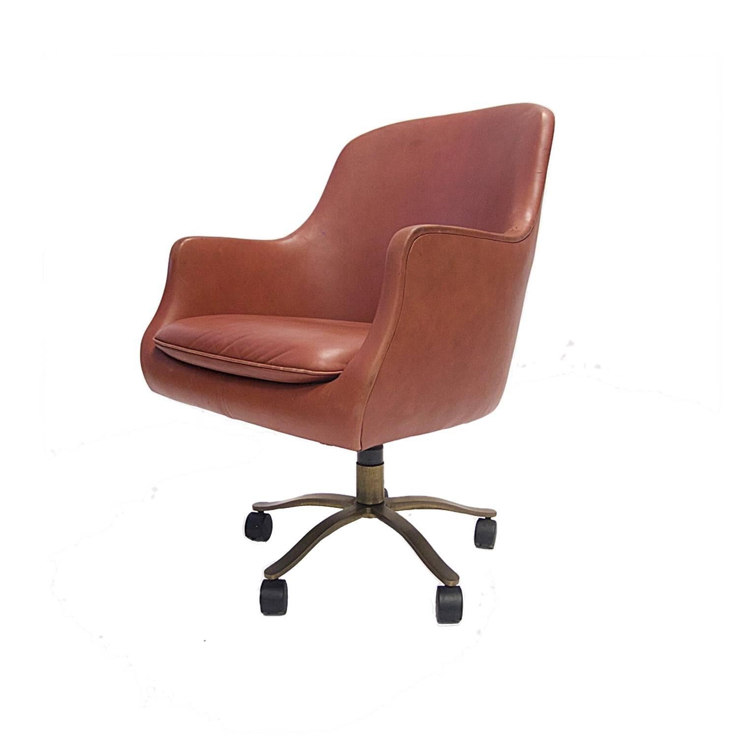 Nicos Zographos English bucket chair with natural dyed leather. Bronze five star base with casters.