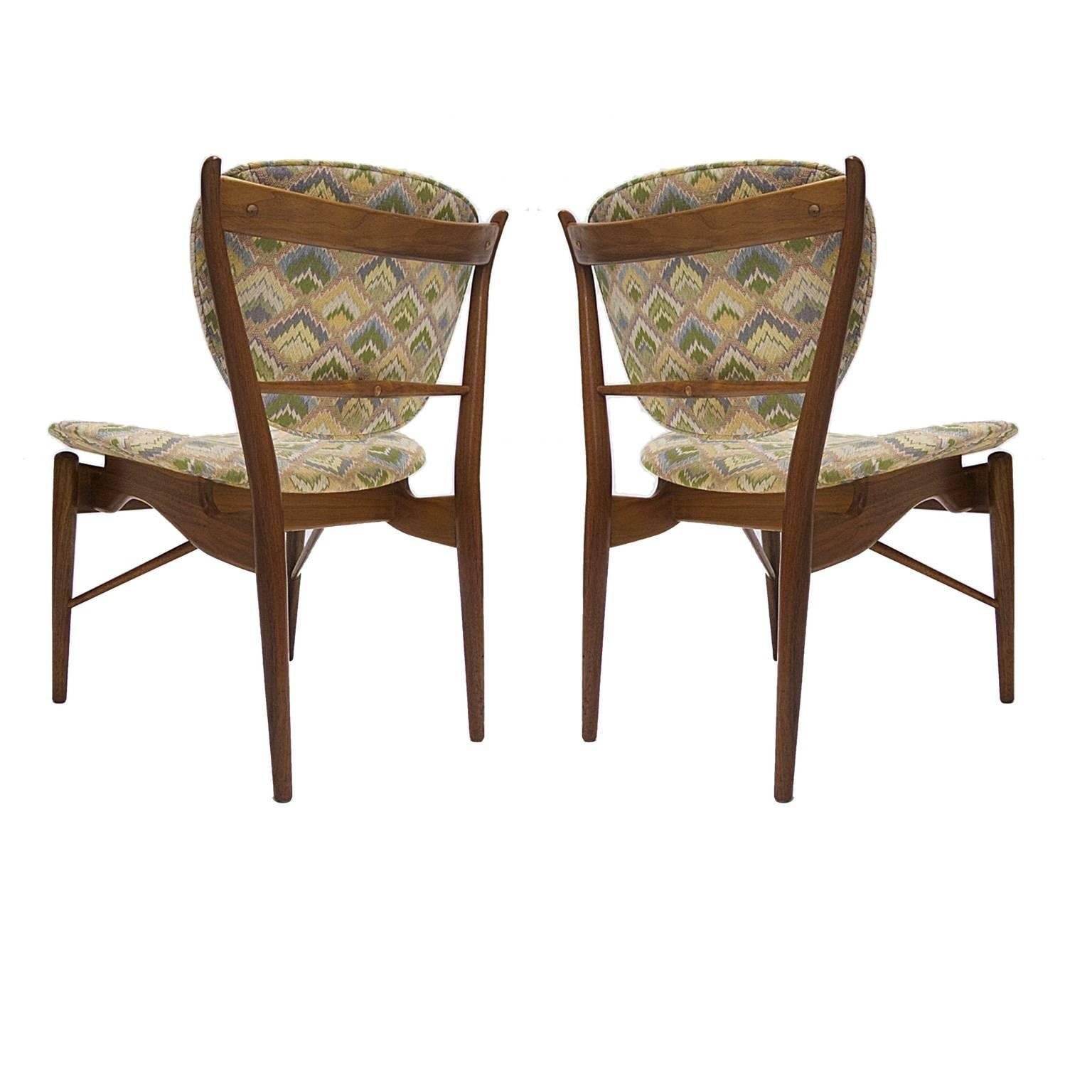 A nice pair of Finn Juhl for Baker Furniture walnut framed chairs. The chairs where reupholstered in a tapestry style fabric at some point.