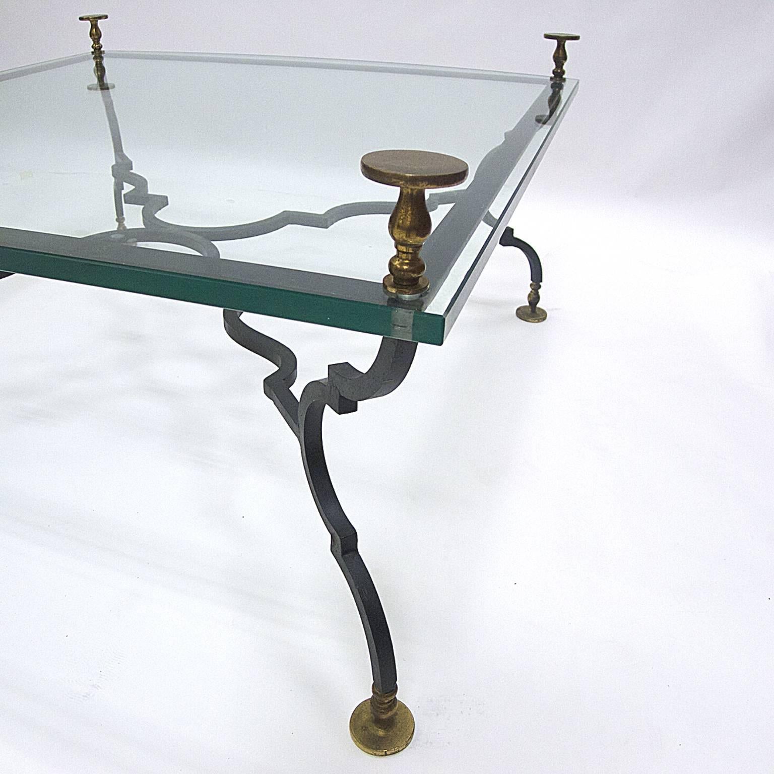 Very heavy decorative wrought iron and glass table with solid brass feet and finials. This table is stunning!