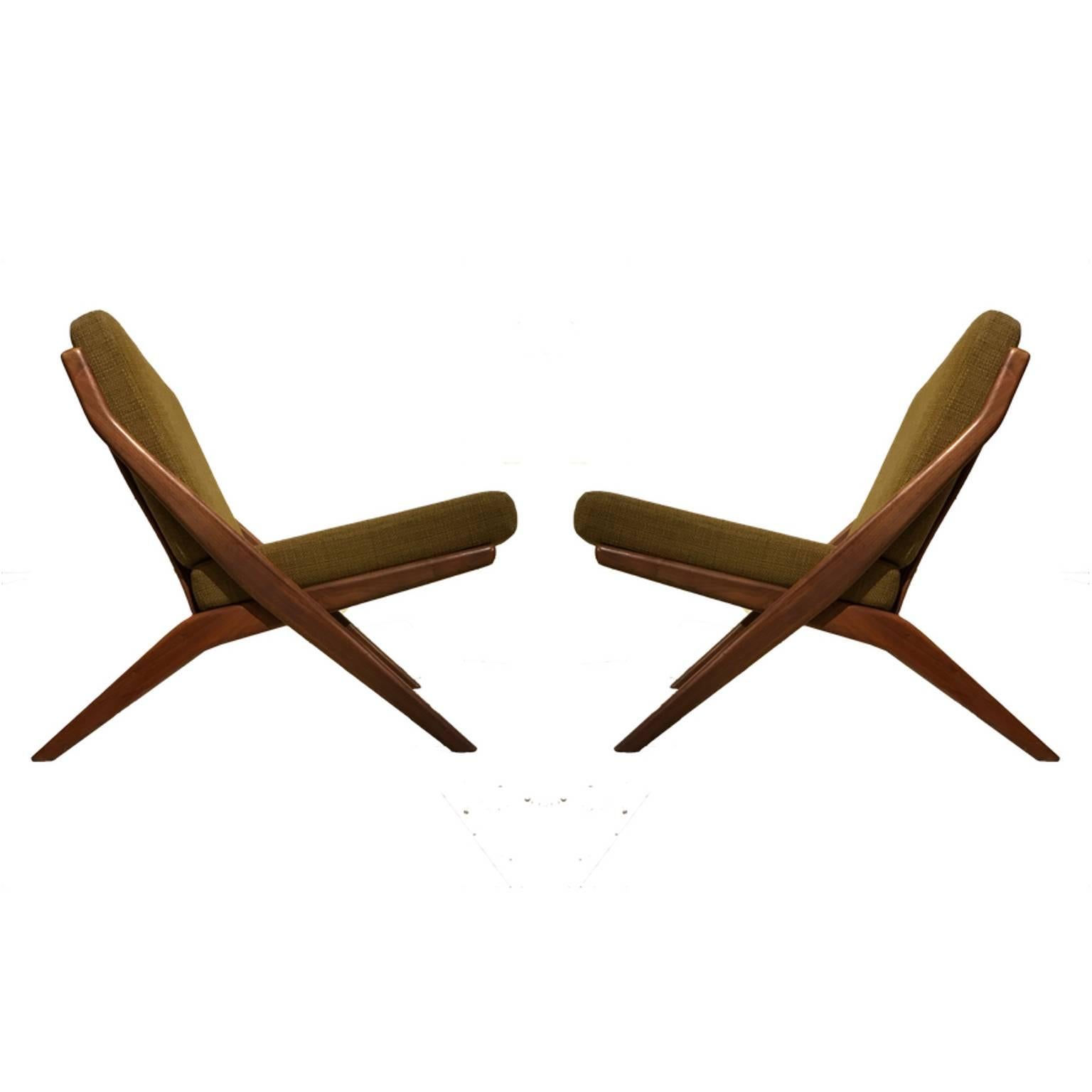 A great pair of sculptural Folke Ohlsson scissor chairs with walnut frames in very good original condition. Straps or webbing in great condition. Original fabric shows very minor wear. Maintains Dux label.