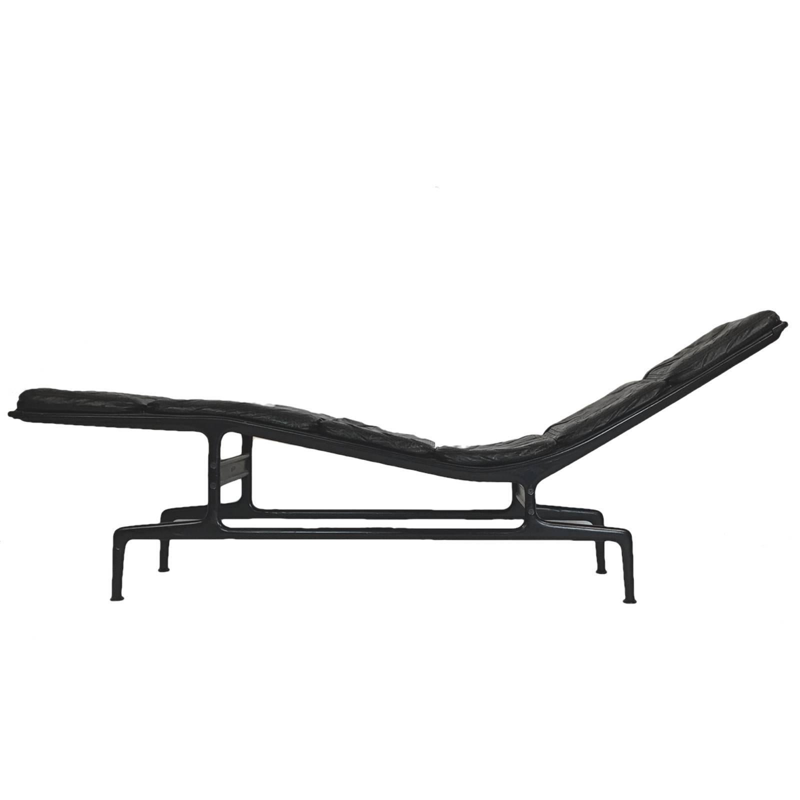 An iconic design by Charles Eames for Herman Miller. Often referred to as the Billy Wilder chaise lounge named after the director for whom the chaise was designed. Black leather cushions with eggplant powder coated frame with two leather