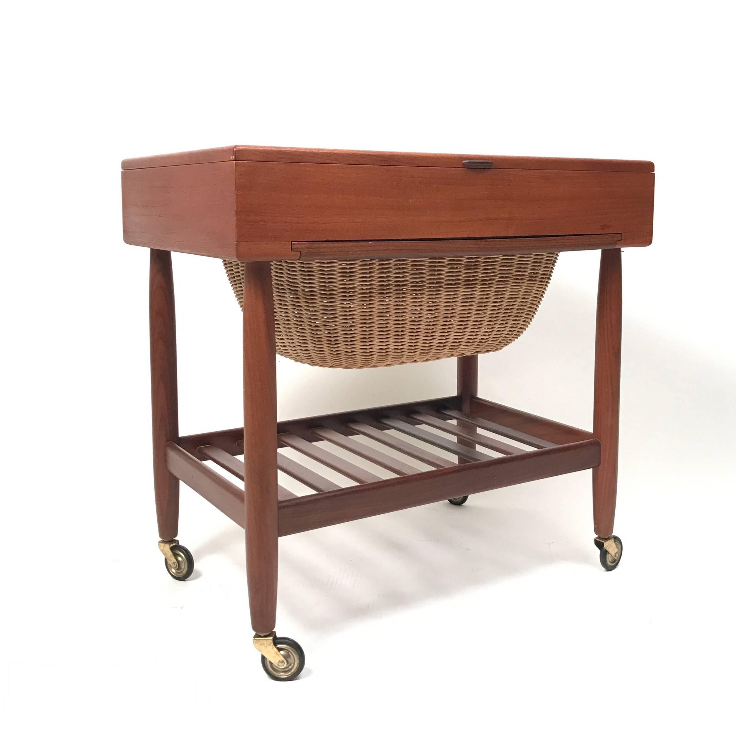 Really great sewing cart. Perfect for end table. Much storage under lift top and additional storage in basket drawer. Really great unique piece. Maker is FDB Mobler.