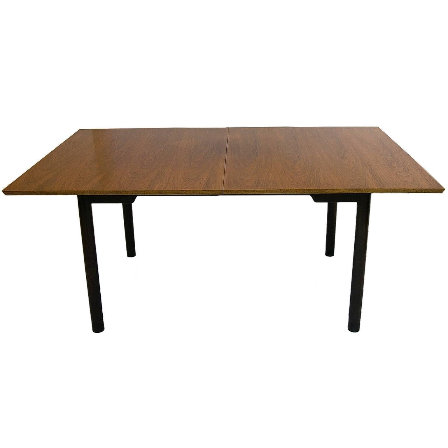 Sleek walnut extension dining table with deep mahogany base and legs. Each leg is wrapped with a stunning leather detail at the base of each leg. Table comes with two extension leaves each measuring 15