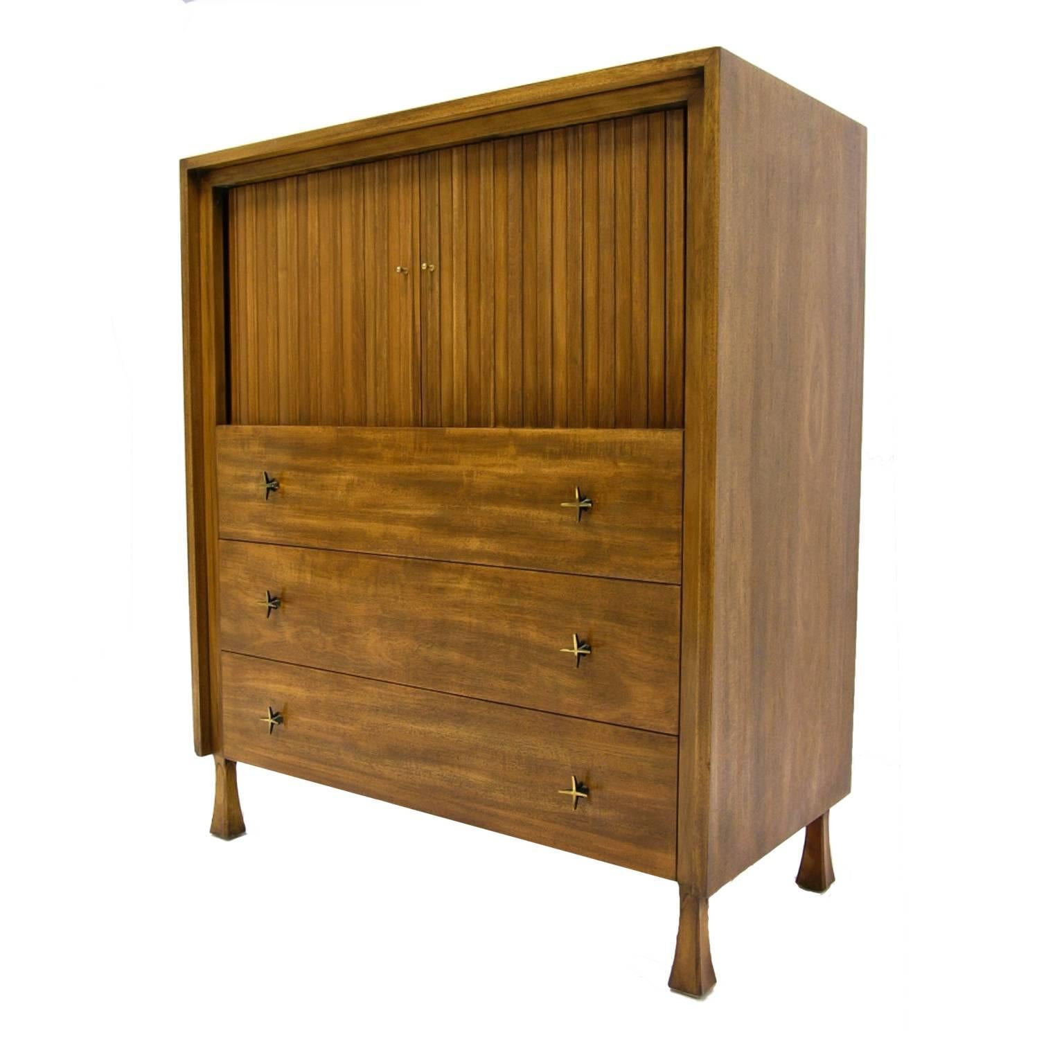 John Widdicomb tall dresser with tamboured doors that conceal several cubbies and one small drawer. The ample sized lower drawers feature star-shaped hardware. The chest maintains beautiful original finish.