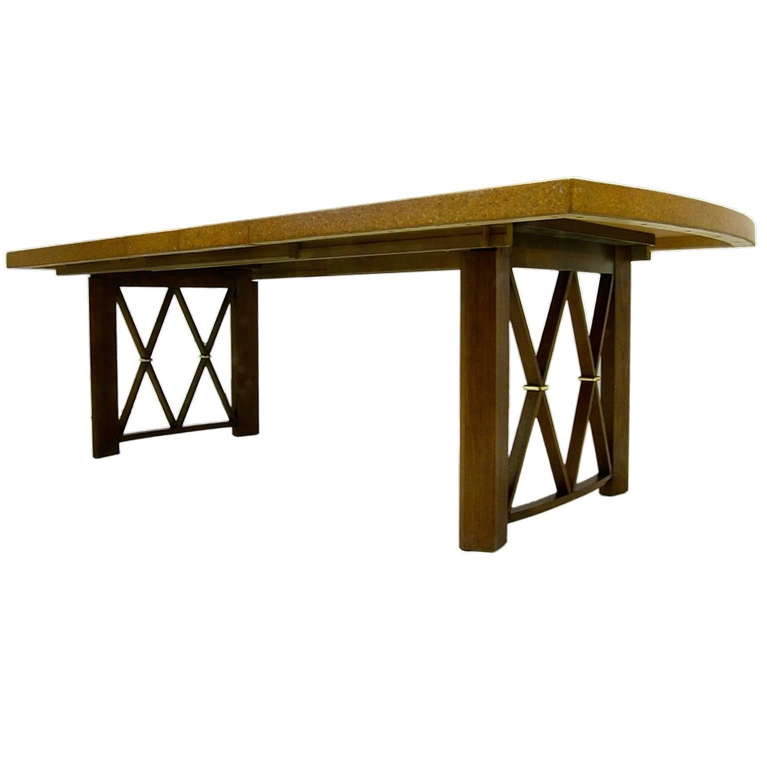 A stunning dining table with cork top and mahogany legs and X detail with brass accent. Designed by Paul Frankl for Johnson Furniture. Measurement includes two 12 inch leaves.