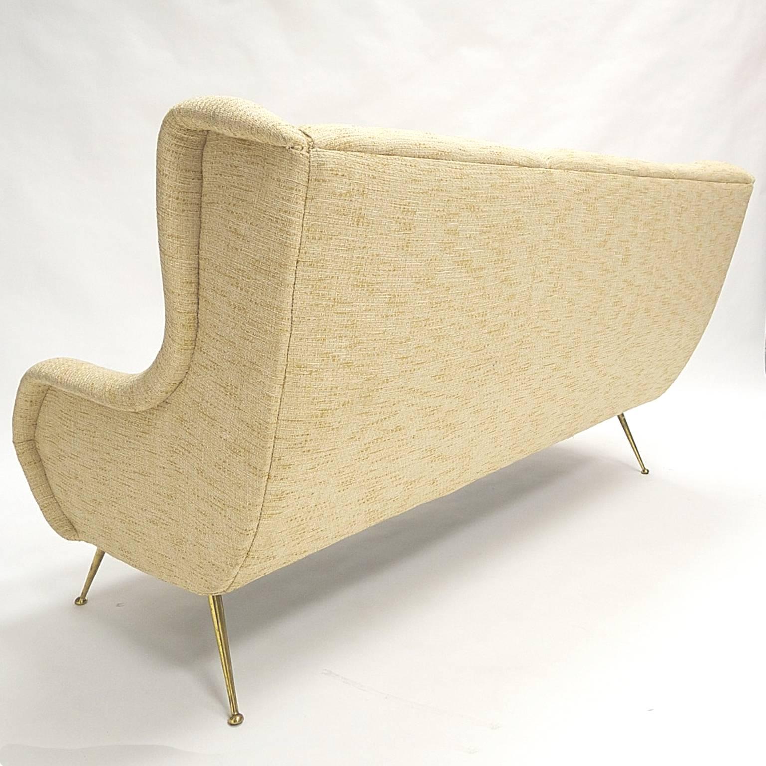 Breathtaking sculptural Italian sofa with tweed like upholstery and brass legs.