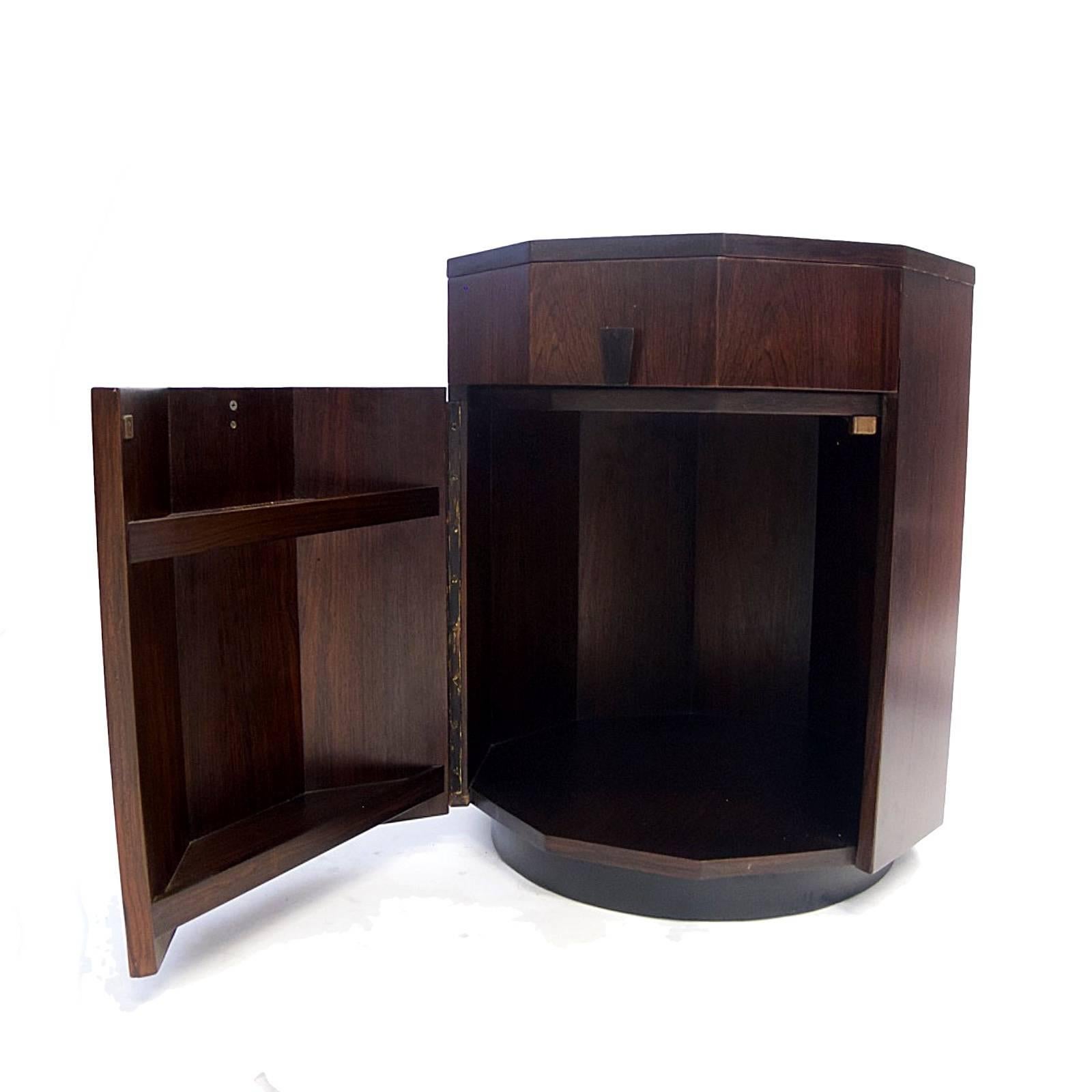 Decagonal shaped rosewood cabinet. Single drawer and cabinet with wood pulls. Cabinet has a lot of storage including shelves integrated into door. Excellent condition.