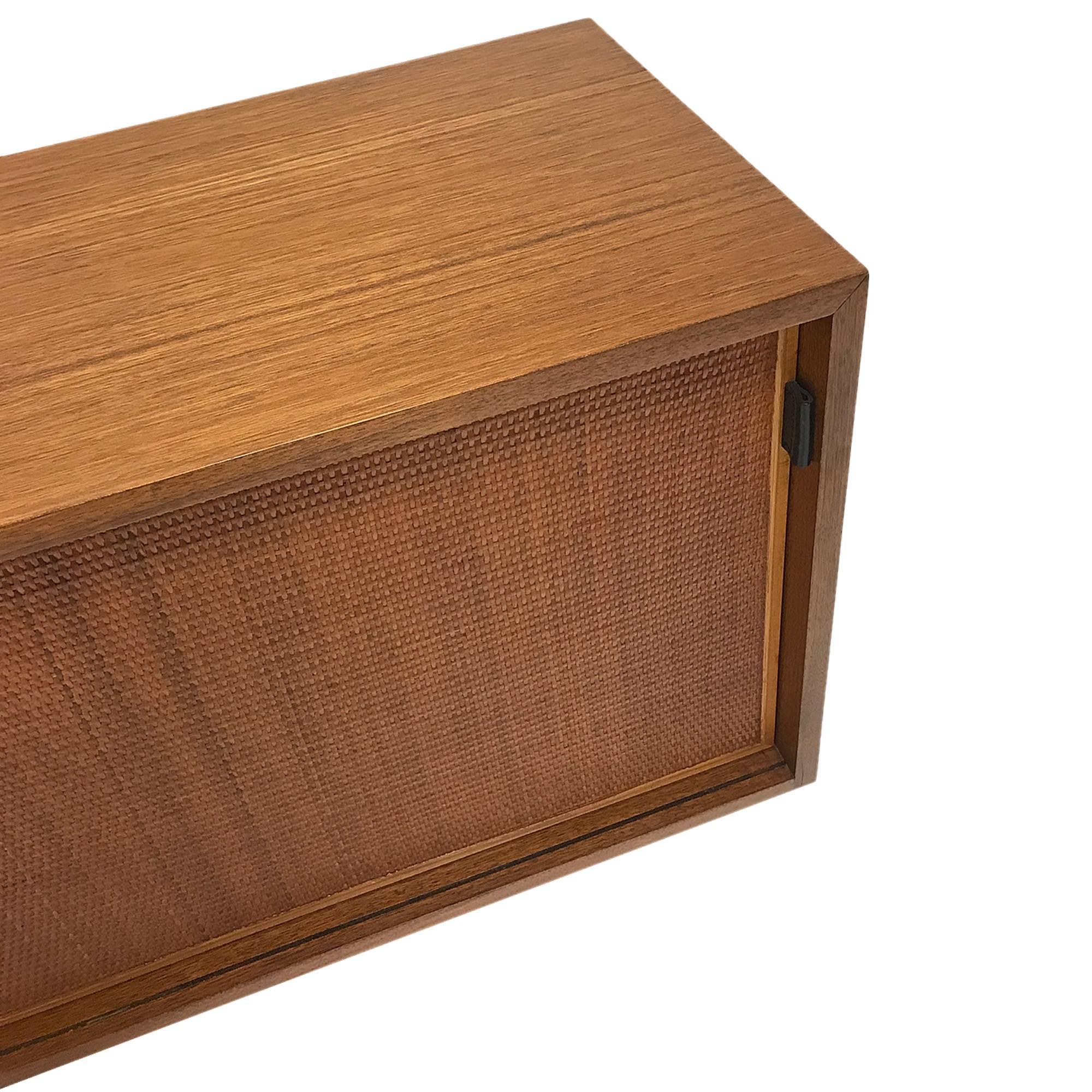 A florence knoll walnut wall hanging credenza with leather pulls and cane doors. The original wall cleat for mounting is included.