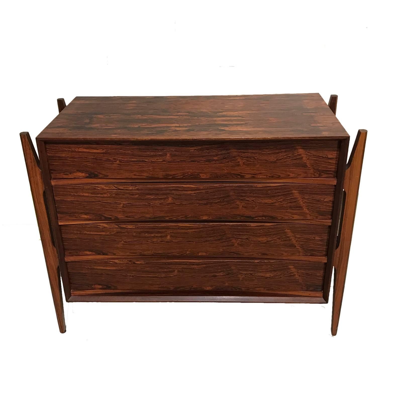 Stunning and rare four-drawer rosewood dresser situated on rosewood stilts. Sculptural design.
