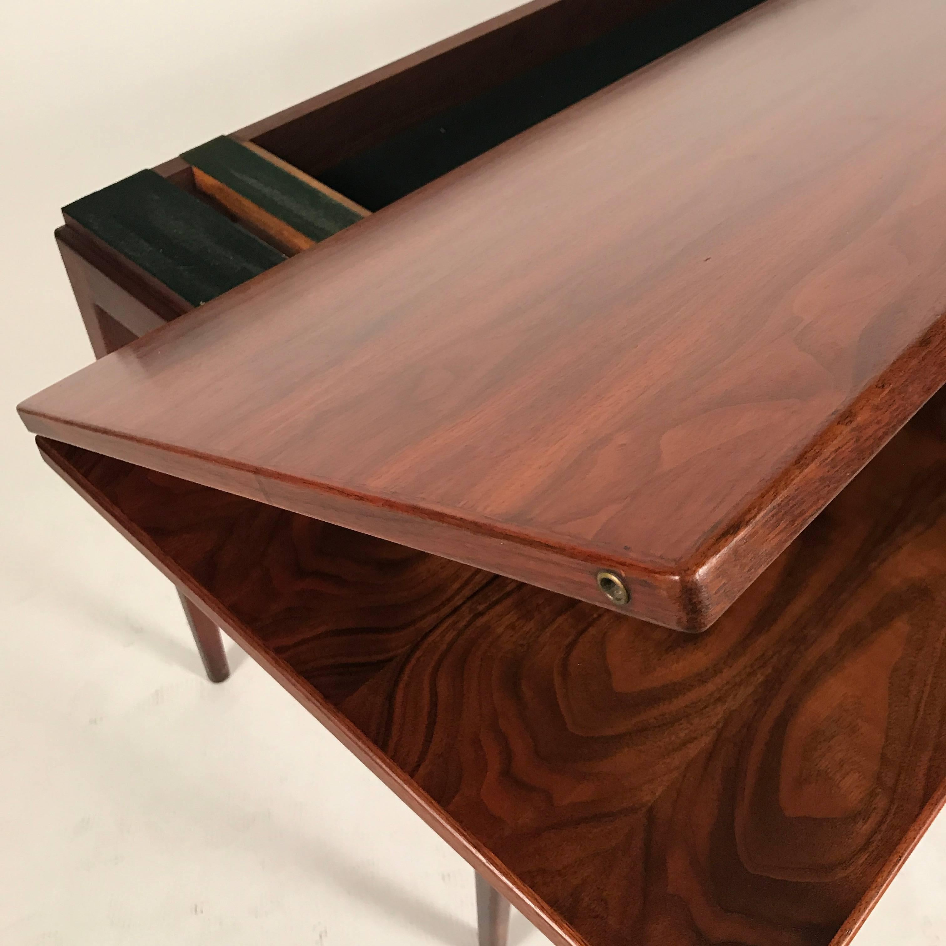 Stunning highly figured walnut flip-top console table designed by Jens Risom. Gorgeous excellent original finish with brass details. This piece works well with many styles including Danish Modern, Midcentury Modern, as well as more classical