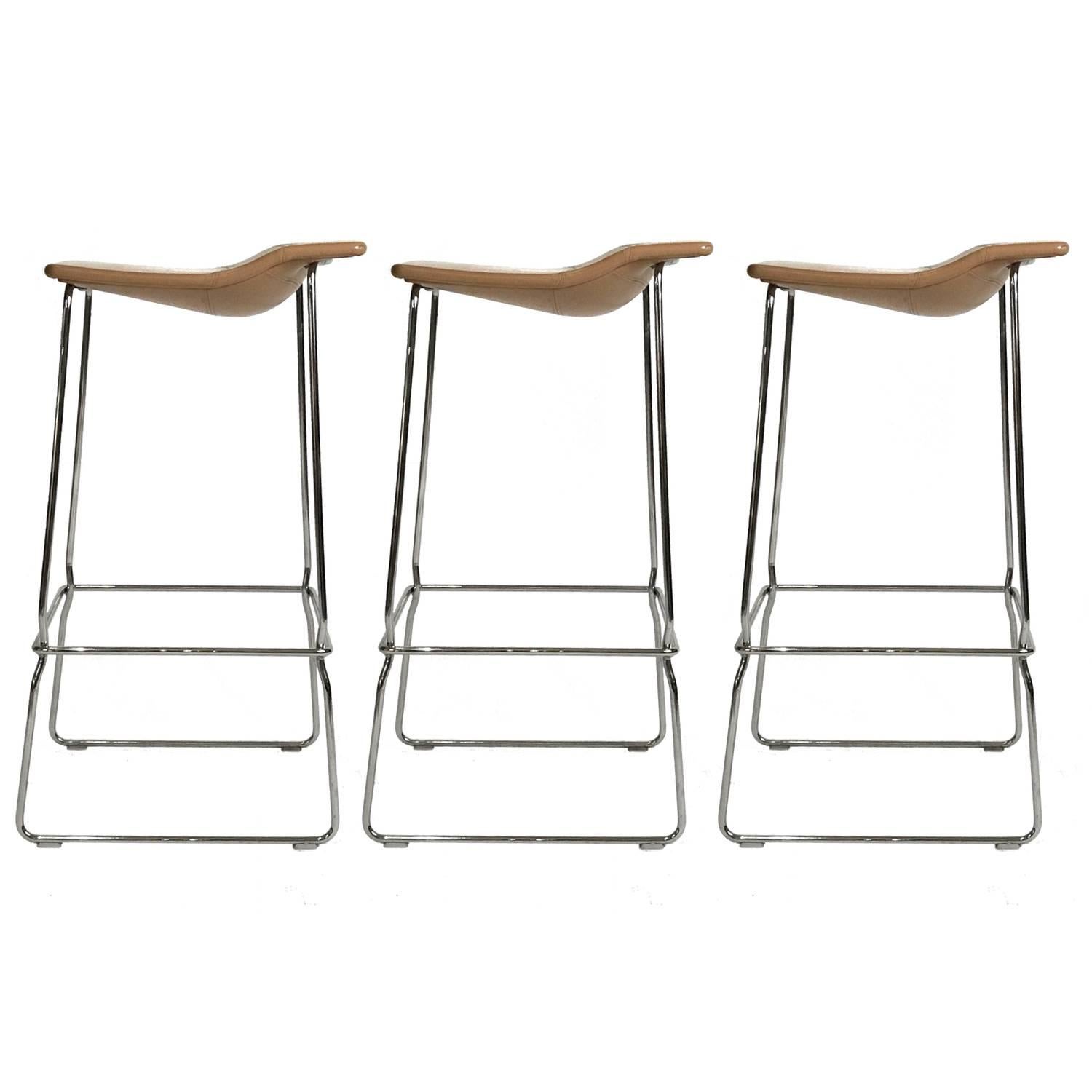 Clean and elegant stool made of flexing steel to offer surprising comfort. Shaped seats in leather with saddle stitch detail. Measures: High stool 31.5” H, 17.25” W, 17” D.