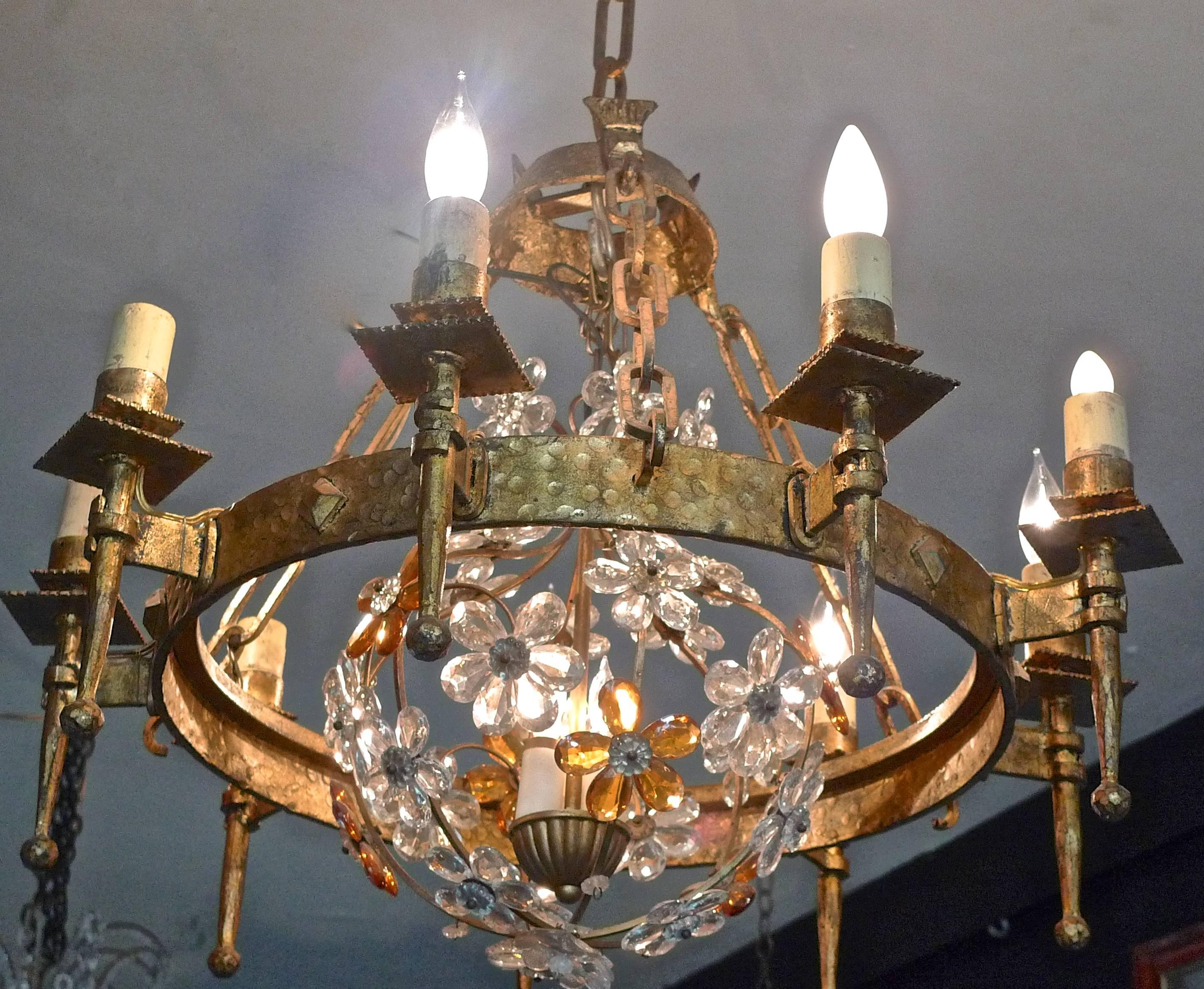 Spanish 1930s round gilt iron chandelier with plain and colored glass. There are nine outer and three inner lights.

    