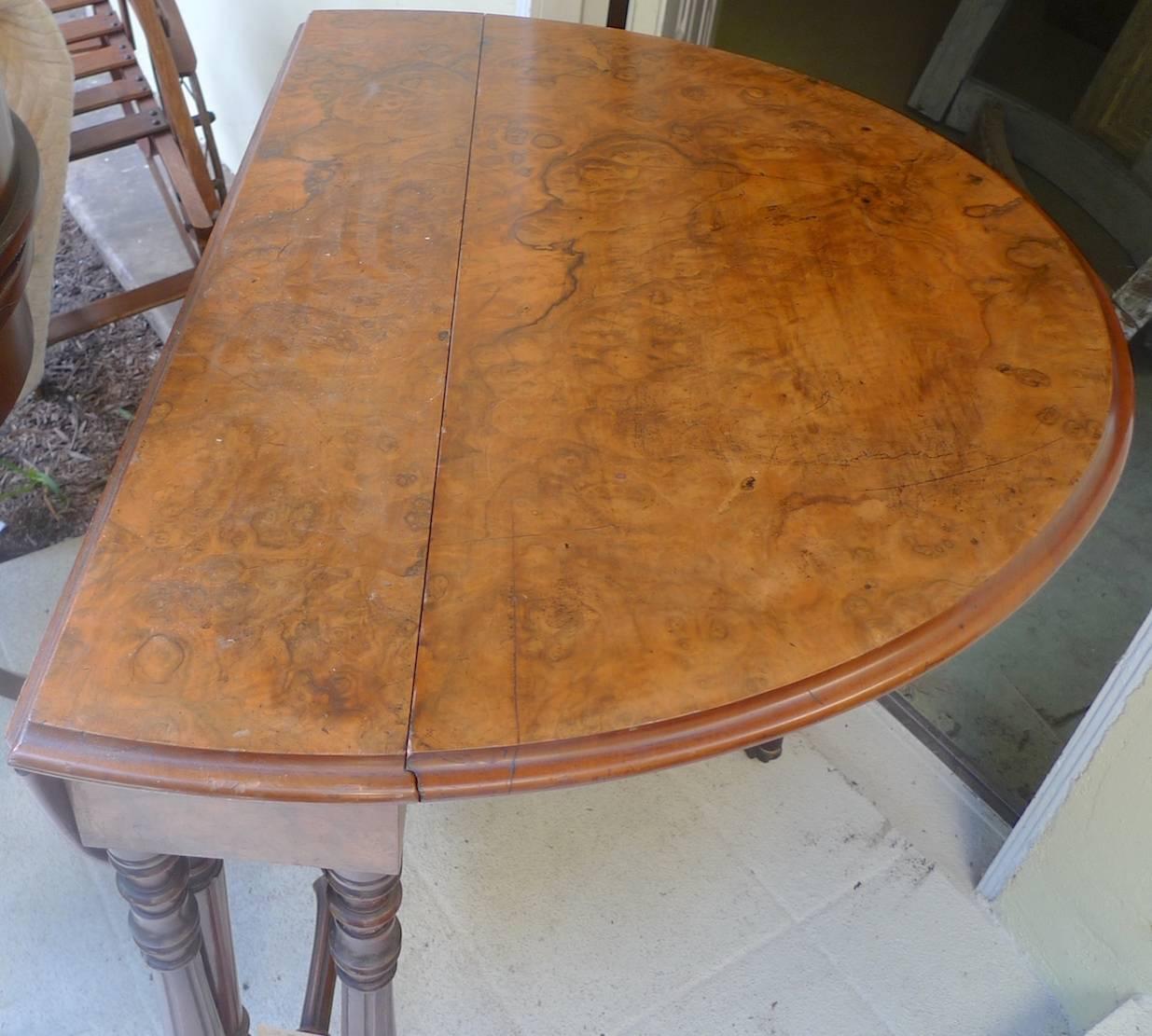 English 19th century burl walnut top, drop-leaf table with carved legs on wheels.