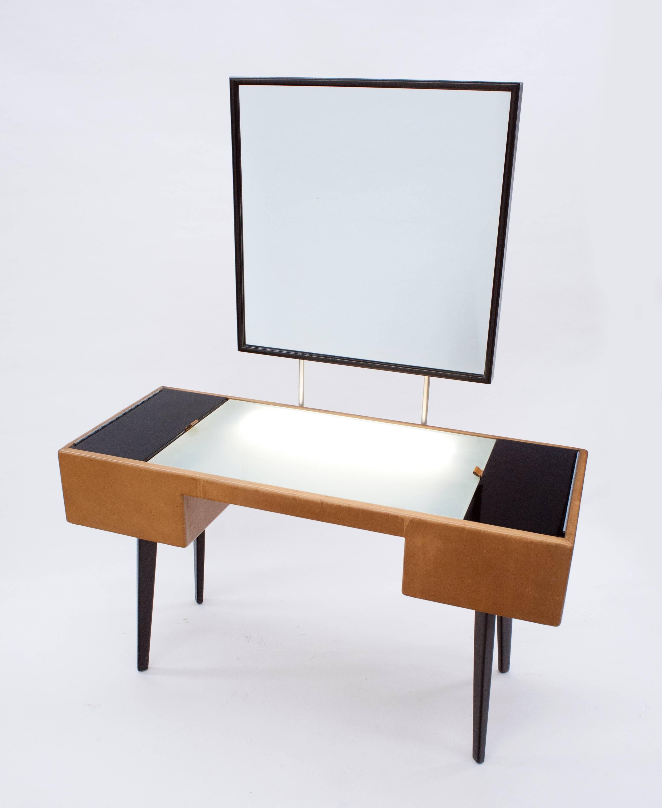 Rare and early Illuminated vanity (model 4660) with original mirror by George Nelson for Herman Miller. Retains original leather pulls to cabinet doors, interior wood trays and original working lighting system with toggle switch. Chair in photos