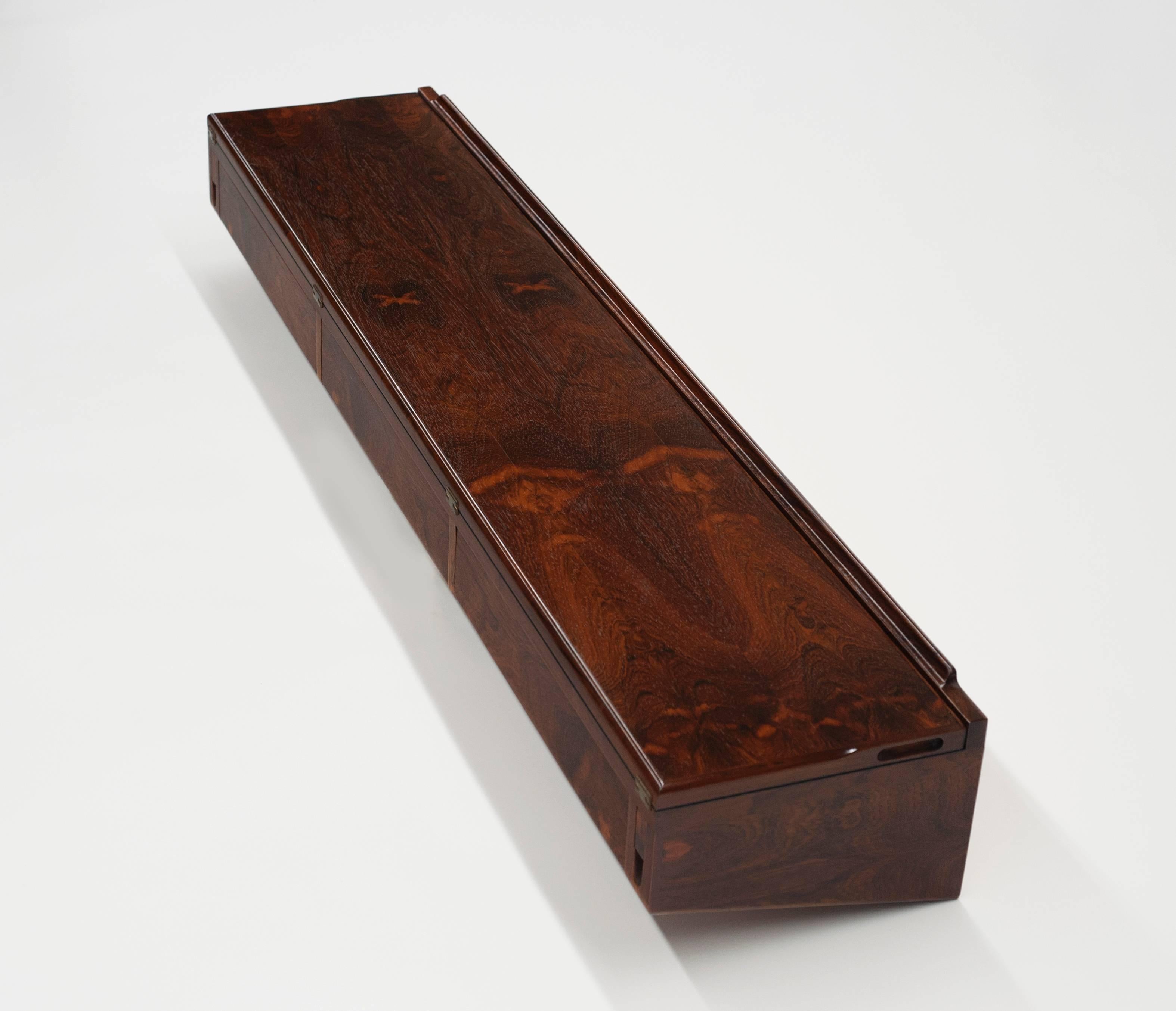 Exceptional rosewood wall-mounted console by Arne Hovmand-Olsen. Quality built in beautiful Brazilian rosewood. Console top flips open to reveal a black laminate that doubles the work space. Perfect for use as a bar or serving space. This is the
