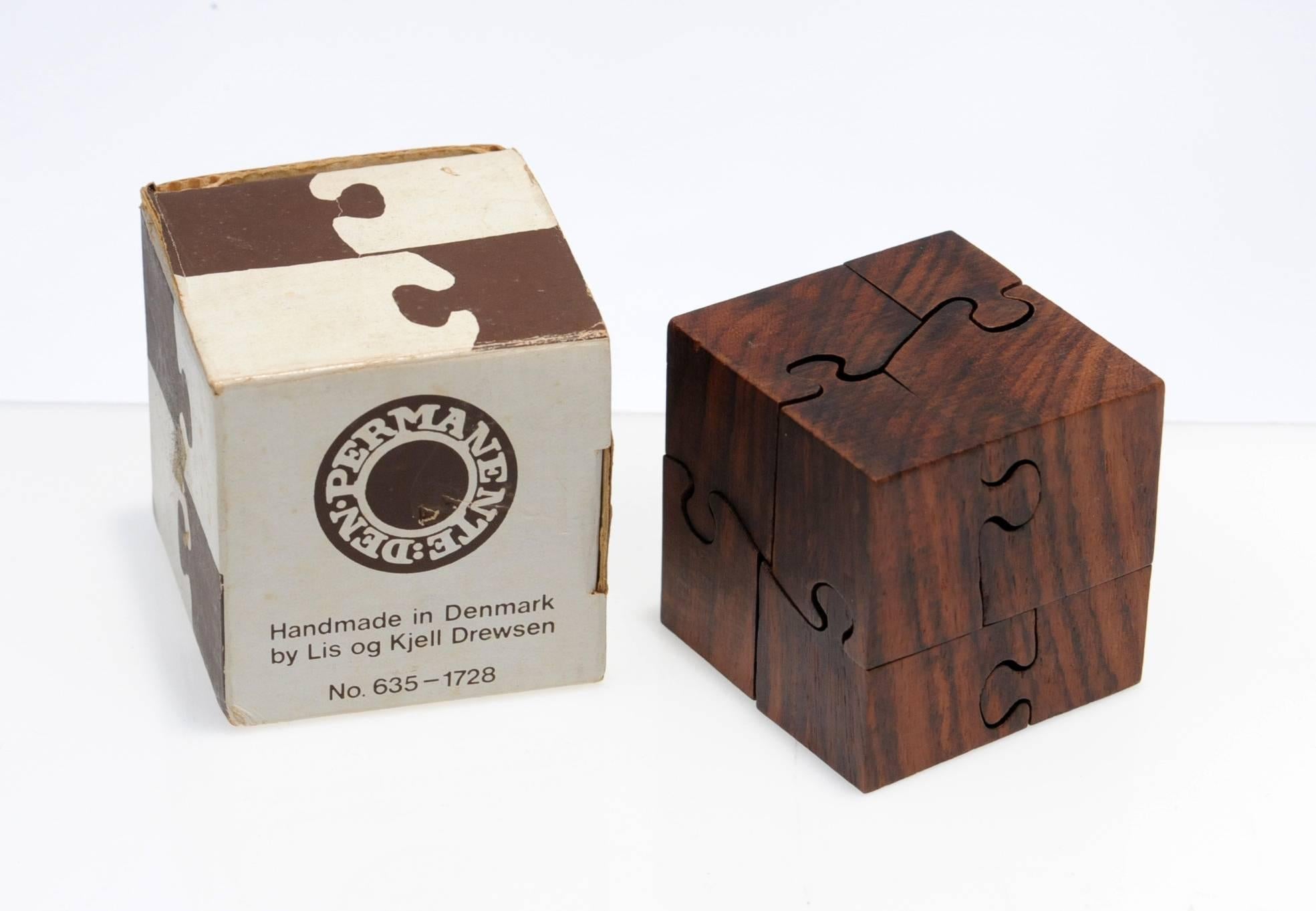 Hard to find, beautiful rosewood puzzle by Lis go Kjell Drewsen, Denmark. Puzzle is handmade and cleverly designed and truly a challenge. Comes complete with the original box. Condition is excellent.
    
