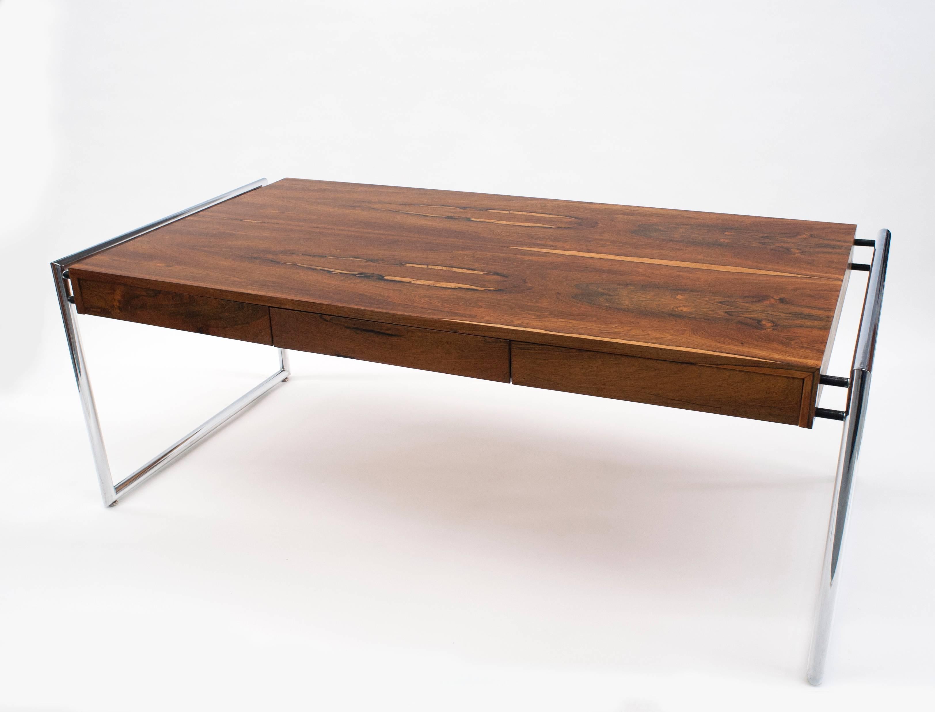 Fantastic rosewood desk attributed to Milo Baughman for Thayer Coggin. Desk is solid and well made with striking rosewood grain. Desk has three drawers and tubular chrome base. Desk has been professionally refinished and is in excellent condition. 