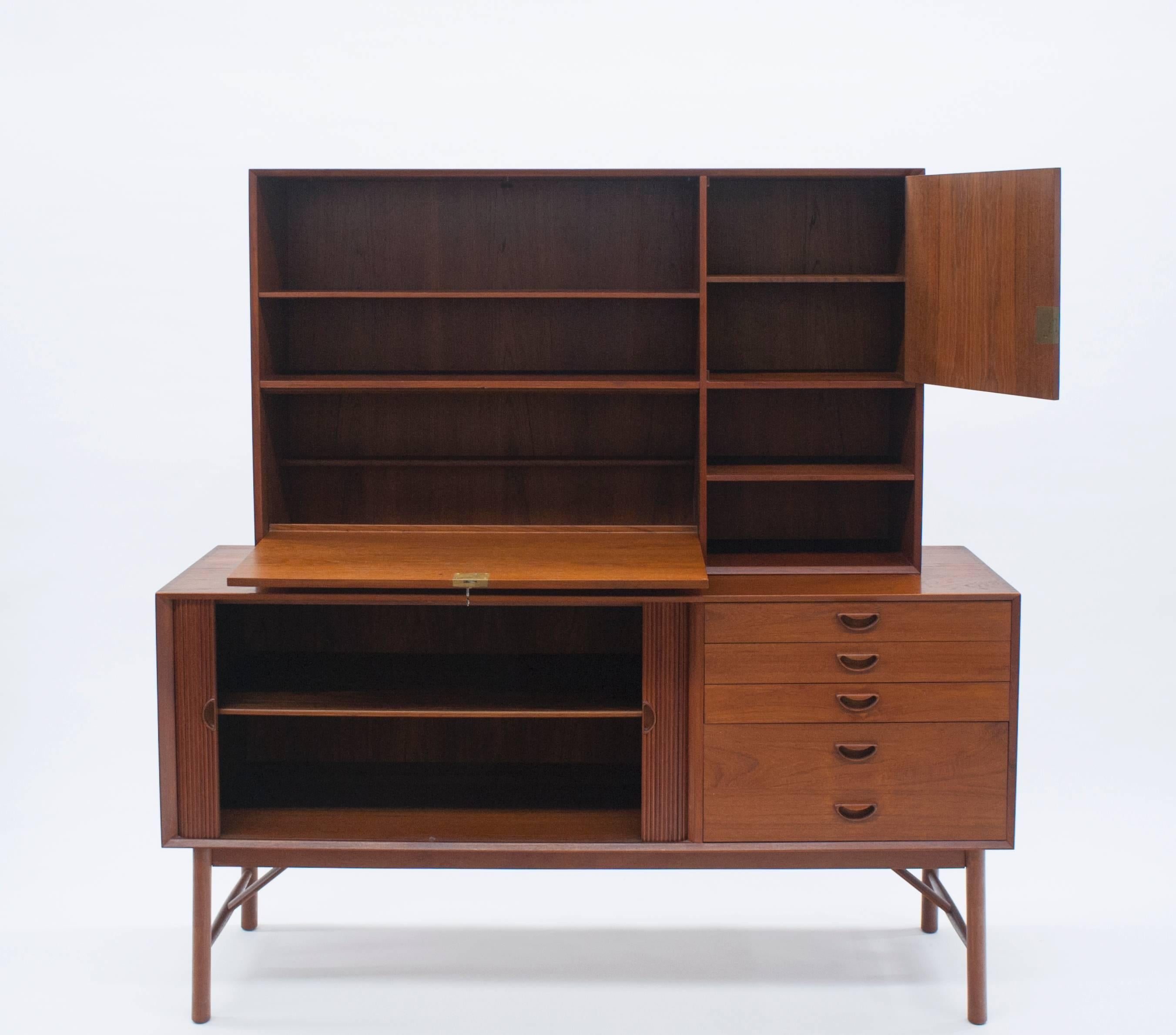 Beautiful and highly functional sideboard with hard to find locking dry bar. This exceptional set is quality made from solid teak with exposed finger joined details. Tambour door opens smoothly to reveal one adjustable shelf with plenty of storage