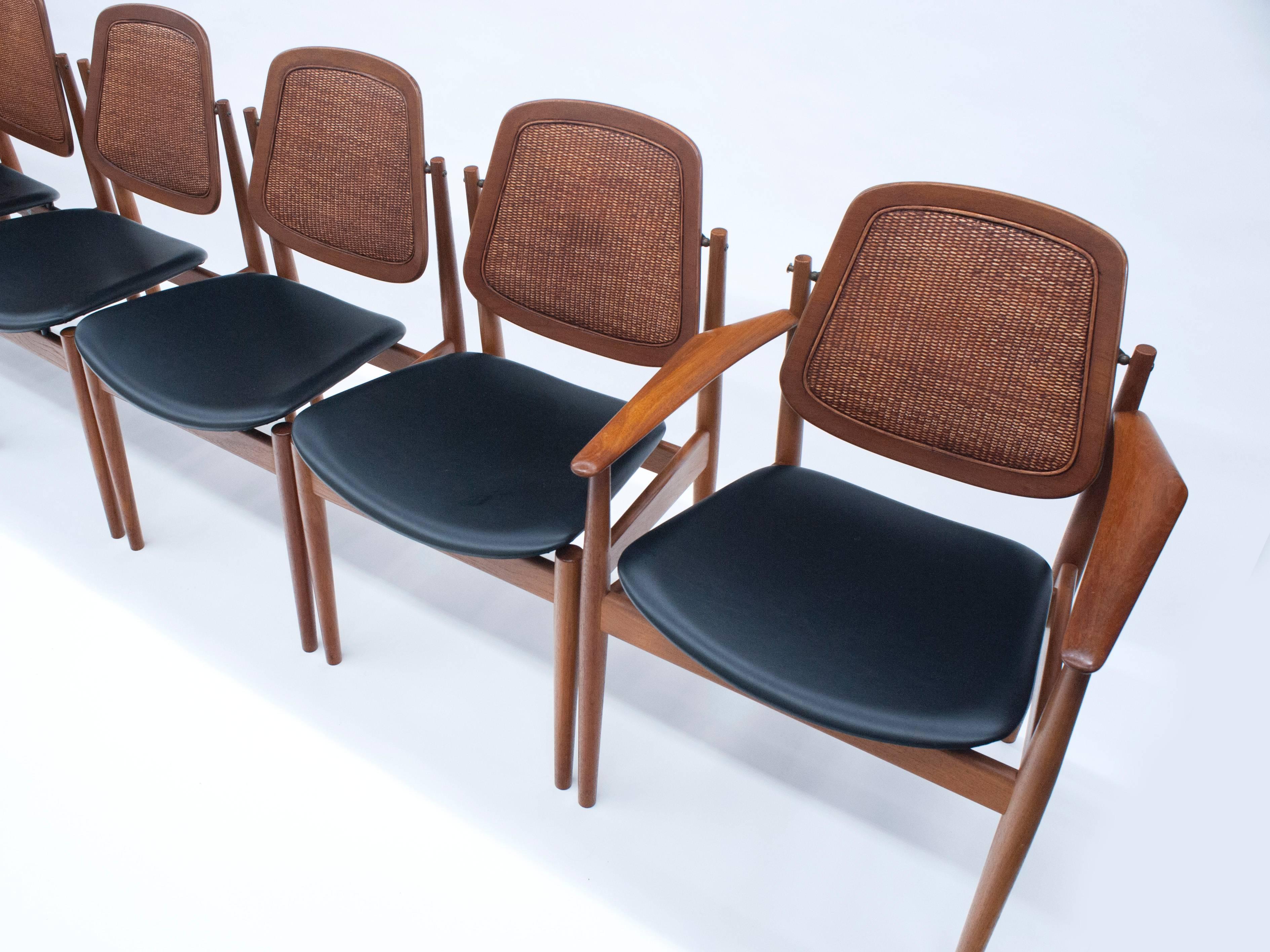 A set of six dining chairs by Danish designer Arne Vodder for France & Son. Chairs have a unique pivoting back with brass hardware. Chairs have been reupholstered with new foam and high quality synthetic leather. Each chair is marked with the John