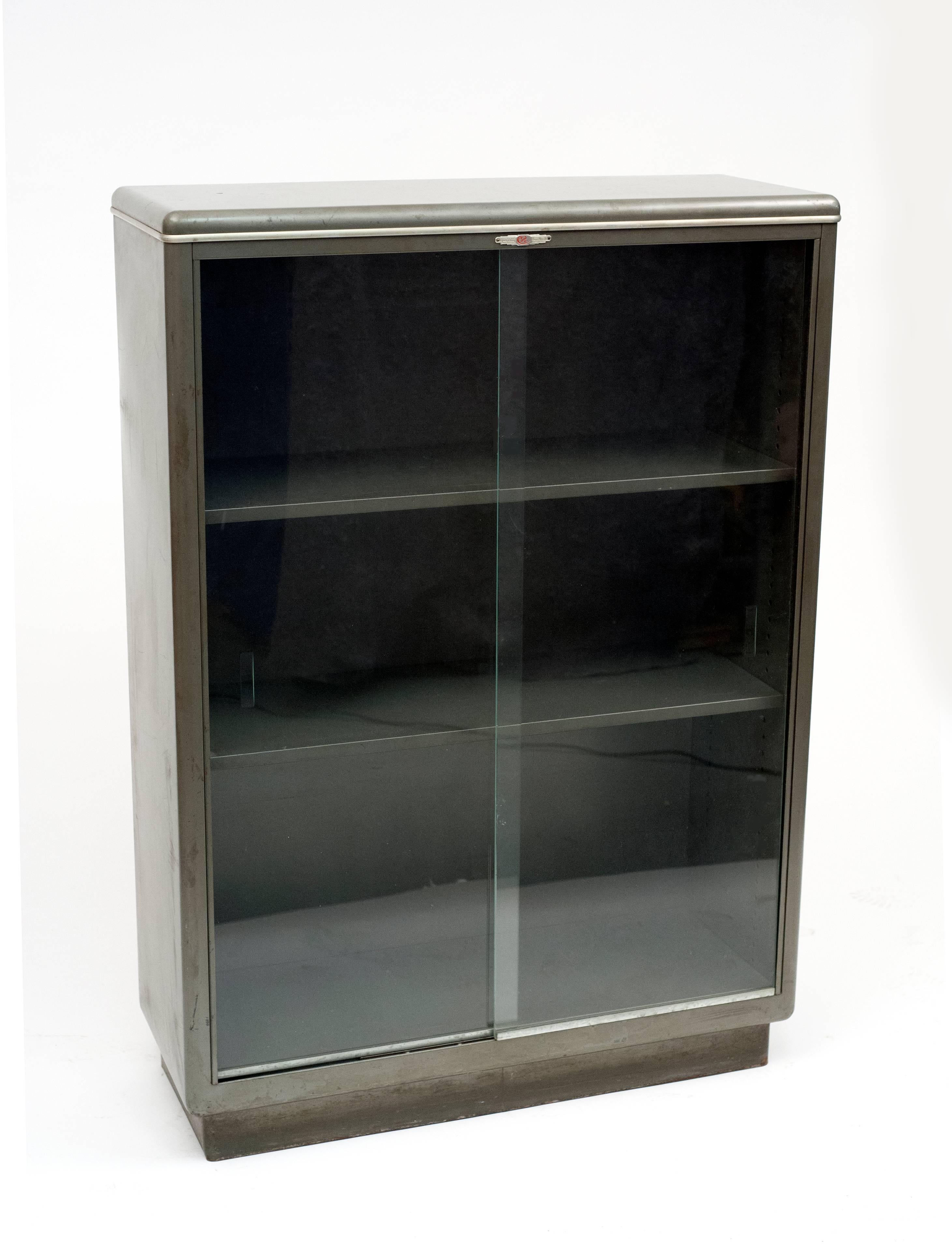 American streamlined Industrial bookcase dating back to the 1940s. Bookcase is complete with original sliding glass doors on ball bearings. Everything is original. Metal shelves are adjustable. Well designed bookcase is a great way to protect books