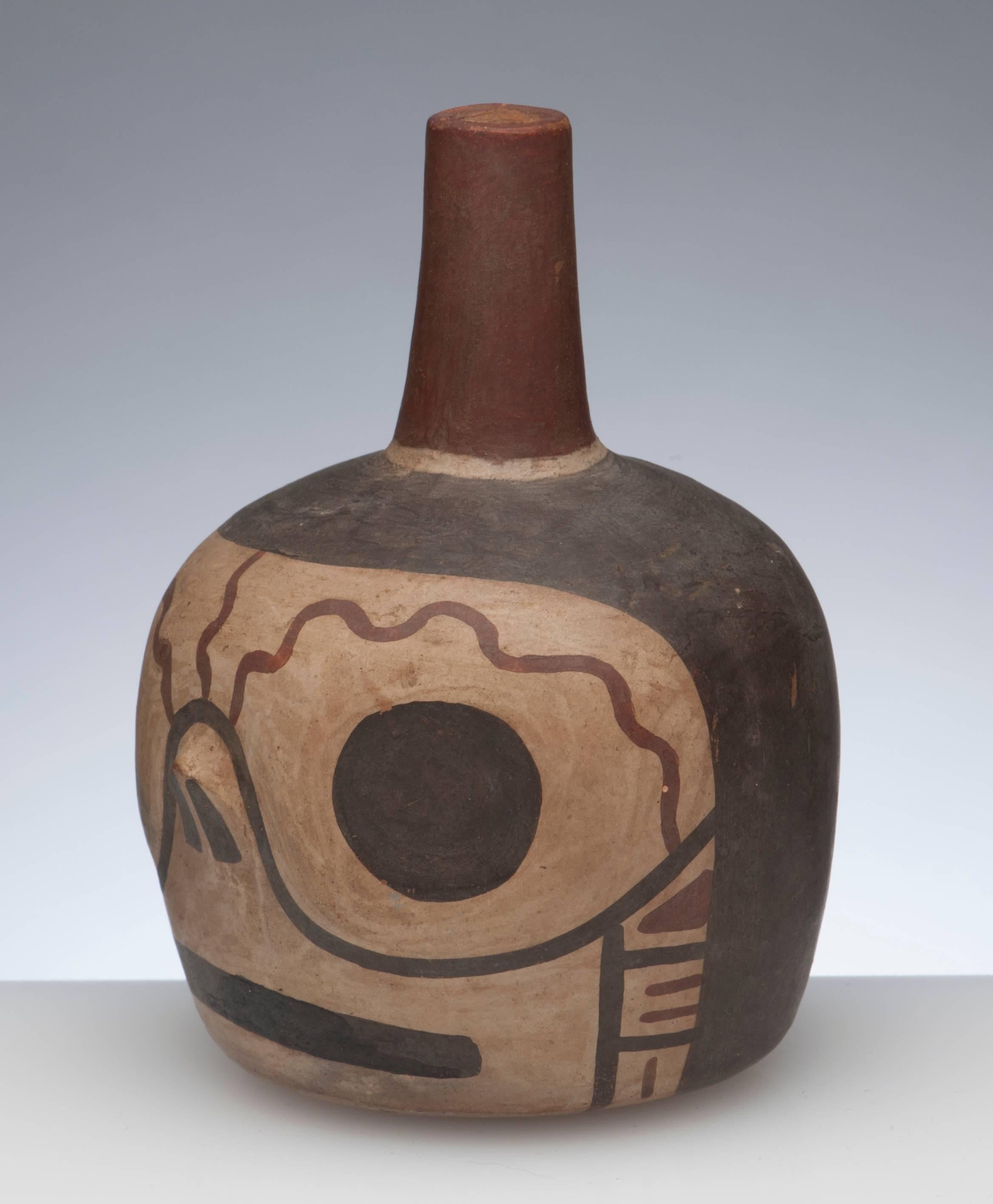 Late Nazca to early Wari (Huari) culture, circa 500-700 A.D, Peru. Near choice pottery jar from the very end of the Nazca empire. Rounded base with straight chimney spout decorated with a slightly whimsical depiction of a human skull.