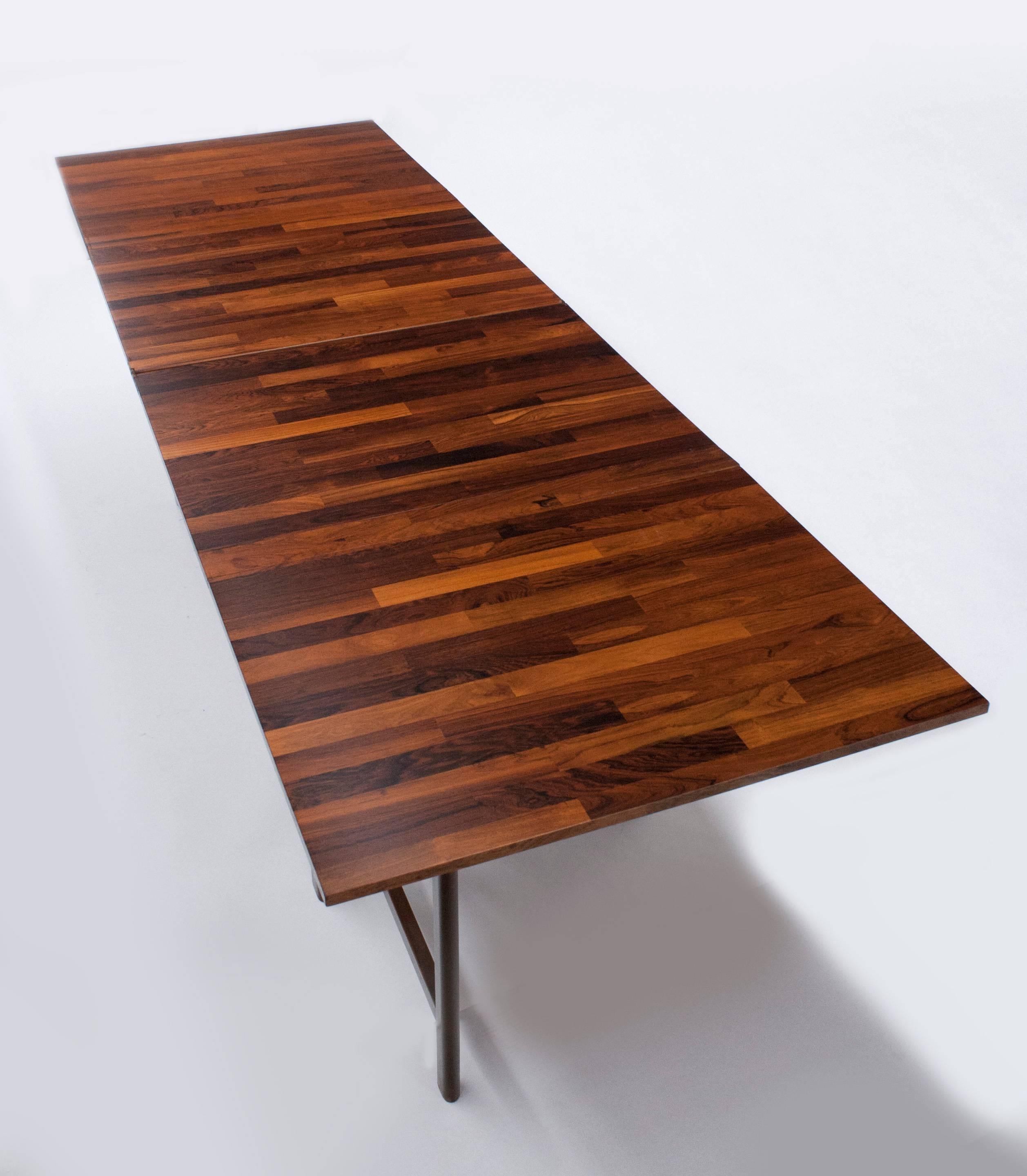 Exceptional butcher block pattern rosewood dining table by Bruno Mathsson.  Incredible design allows for table to be reduced to just 9.5 inches wide and then unfolded into various lengths. When completely extended table measures 28.5 H x 110 in W x