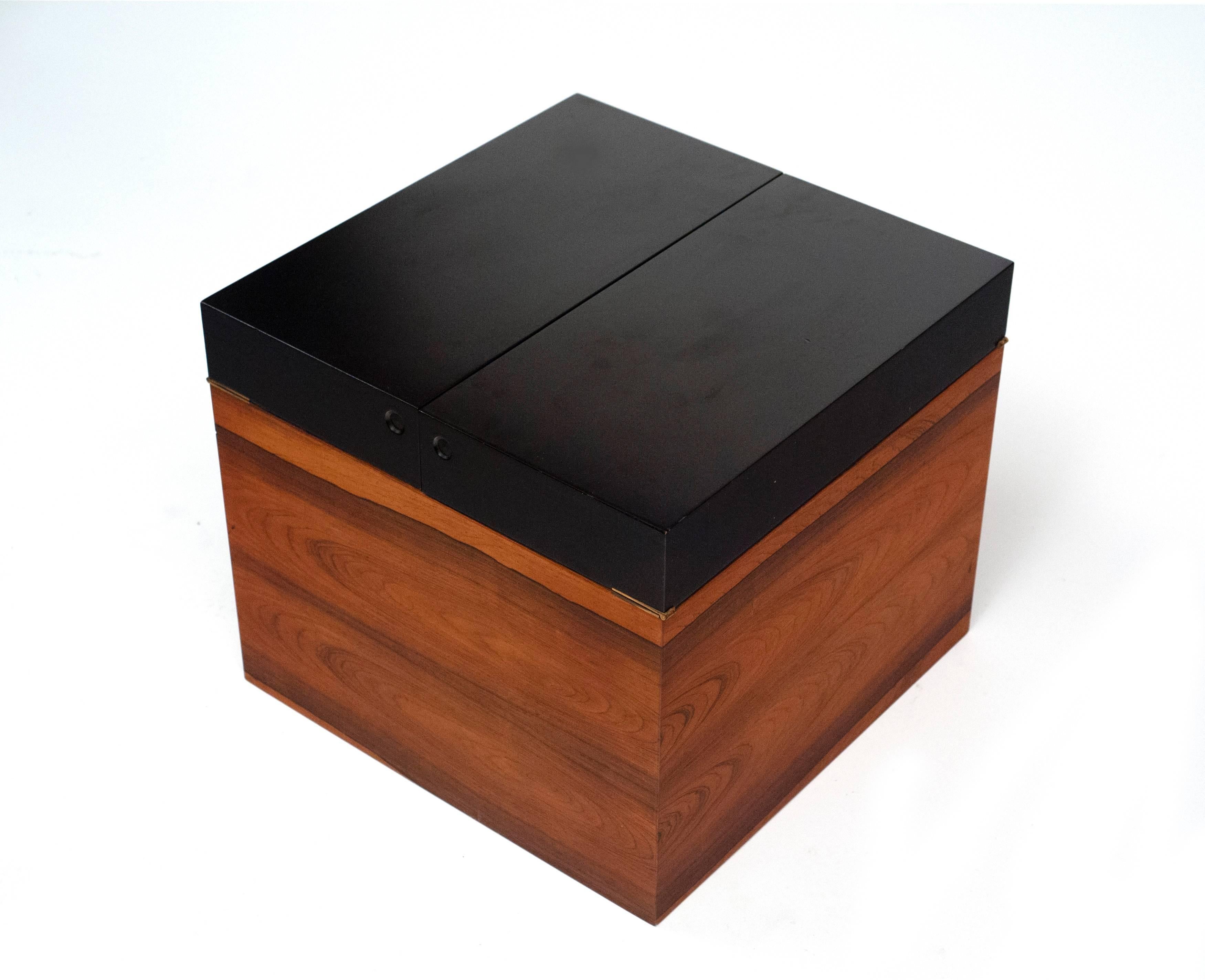 Attractive and functional rosewood box by Gunnar Myrstrand for Kallemo of Sweden. Black lacquered flip-top doors conceal a removable rosewood tray and solid brass hinges. Four round chrome casters allow it to be moved with ease. Box works well as a