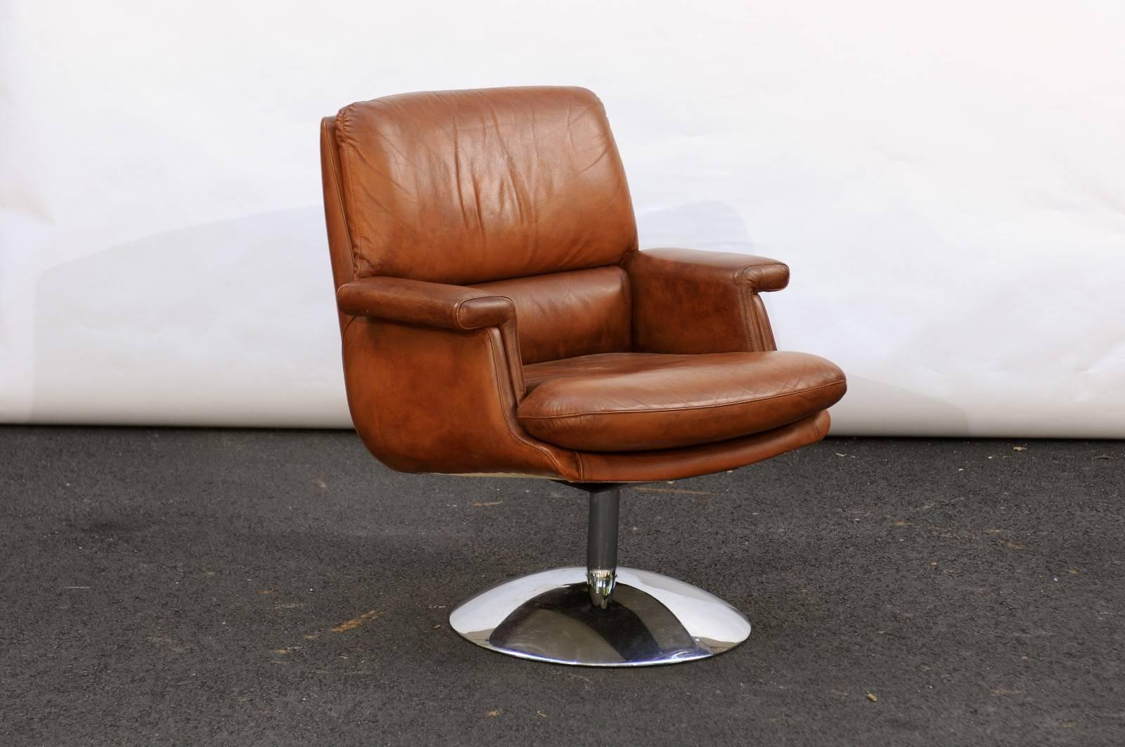 A French Mid-Century Modern leather armchairs with aluminium tulip shaped base. Feels like buttah! That’s what we said when we touched this comfortable leather armchair at a market in Paris. This caramel colored vintage 1960s leather armchair is