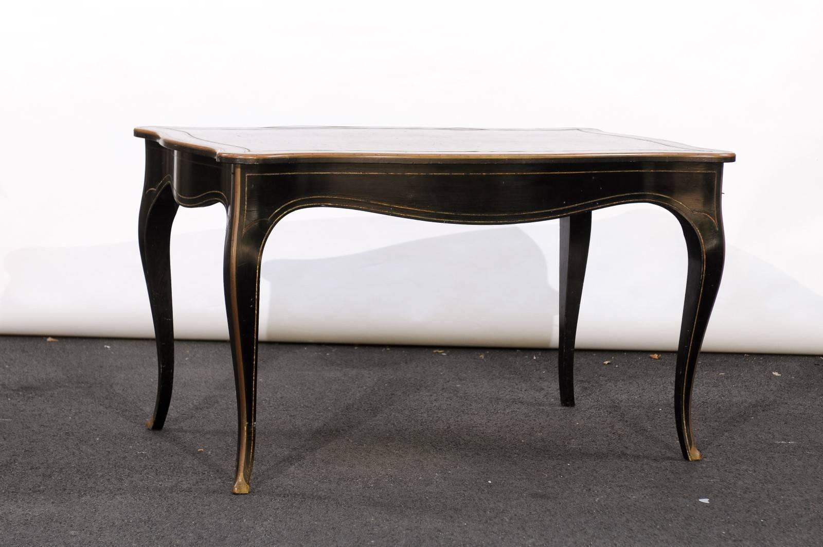 This French Napoleon III style ebonized wood writing table features a sinuous top with gilded accents in the border over four cabriole legs. Something tells us we will be fighting over this table! In the style of Napoleon III, this piece can work as