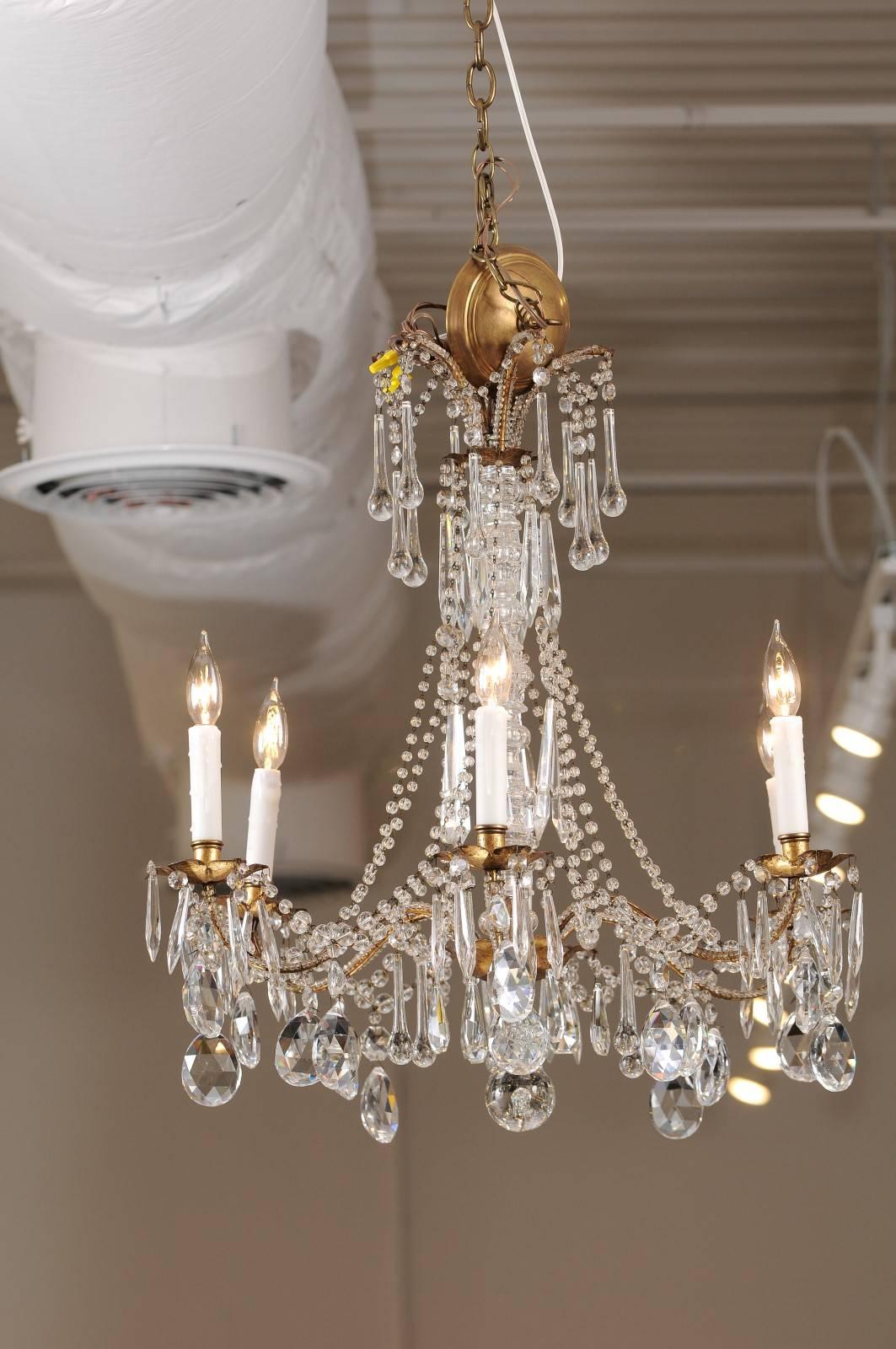 This French six-light crystal chandelier from the first half of the 20th century features a gilded metal armature adorned with a variety of faceted crystals. We found this 1930s chandelier in France and fell head over heels for its elegant display