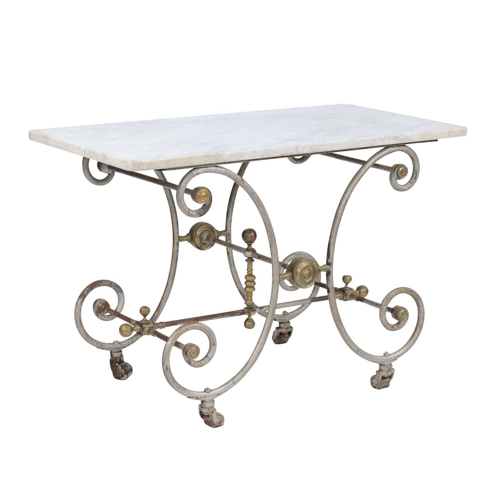 A French early 20th century baker's table with marble top and curly iron base with silver and gold accents. We love a gorgeous baker’s table, and this one from the 1900s doesn’t disappoint! We were first drawn to the exceptional rose colored marble