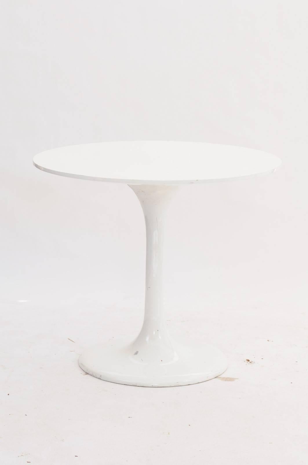 A French Mid-Century Modern white resin tulip round dining or center table from the 1970s. A mélange of vintage beauty and contemporary artistry, this white resin tulip table takes style to a whole new level with its clean lines, sleek body and
