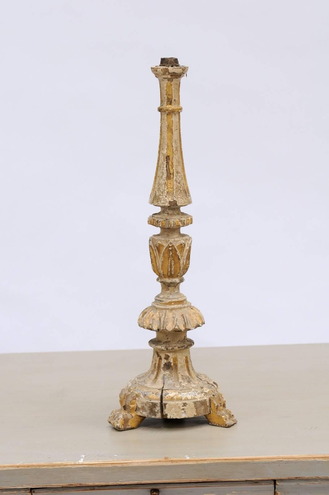A small size 18th century painted candlestick with traces of gilding, fluted body and floral motifs from Portugal. Featuring carefully carved details, an elegant patina and three charming claw feet, this Portuguese candlestick wears its age well. A