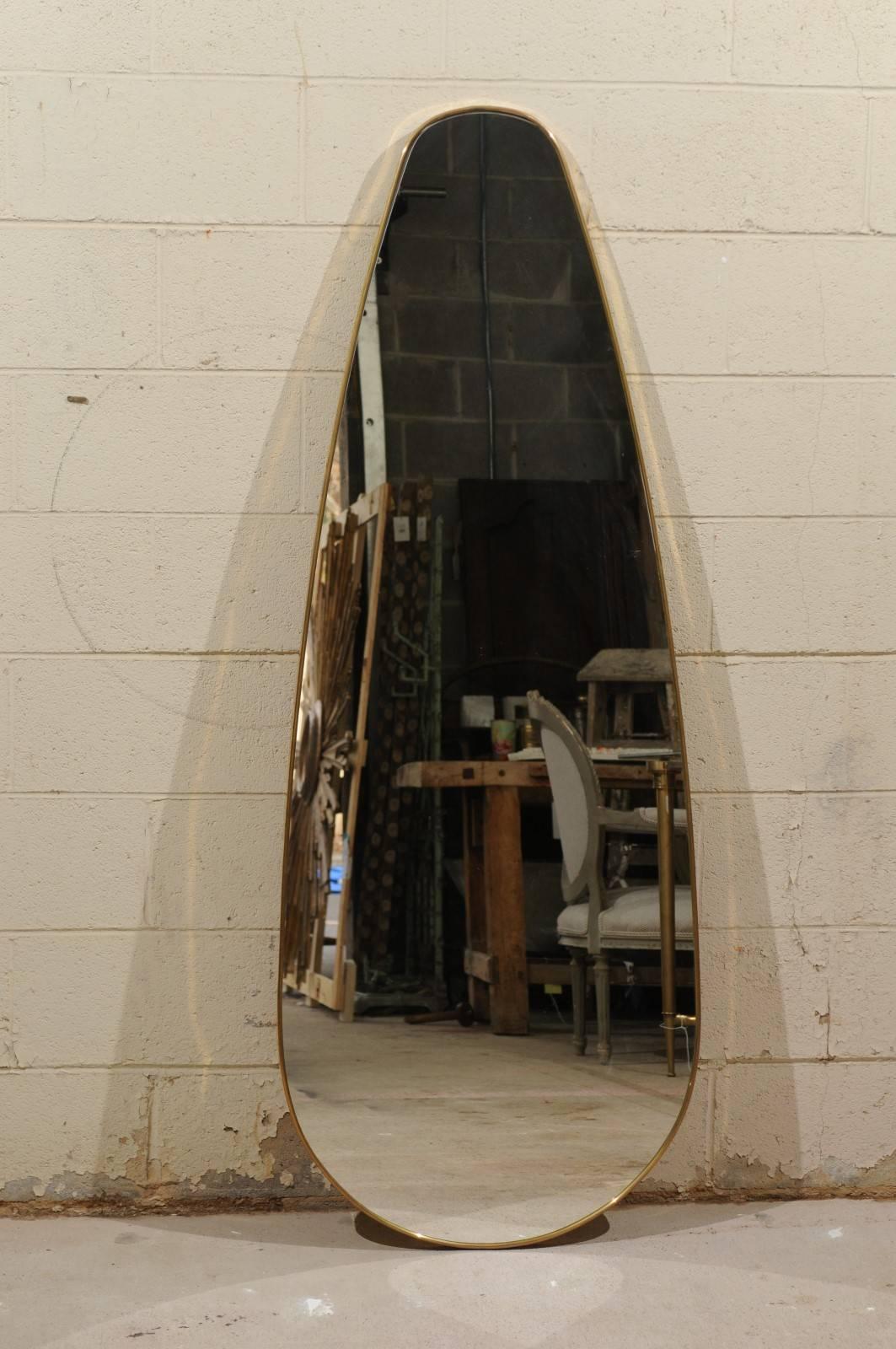 An Italian vintage 1970s oval tall mirror with brass teardrop frame. We're always on the lookout for unusual finds, and this large oval mirror, born in Italy in the 1970s, is a one-of-a-kind wow. We love the retro feel of the brass frame, the size