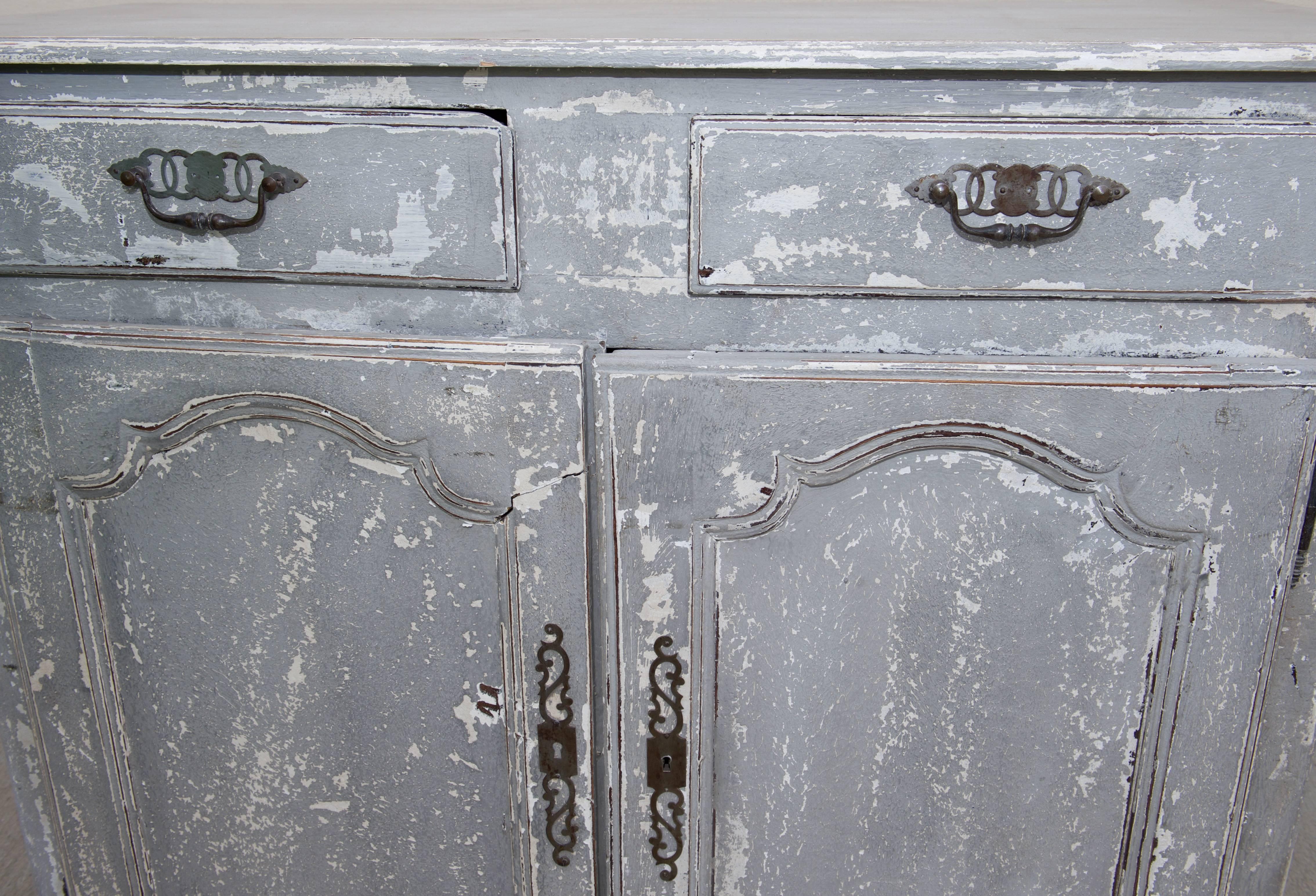 A French painted oak Louis XV style buffet with two drawers over two doors from the late 19th century. This is a handsome and tall Louis XV style French buffet circa 1890 with a crackly painted finish and the original hardware and key. The piece
