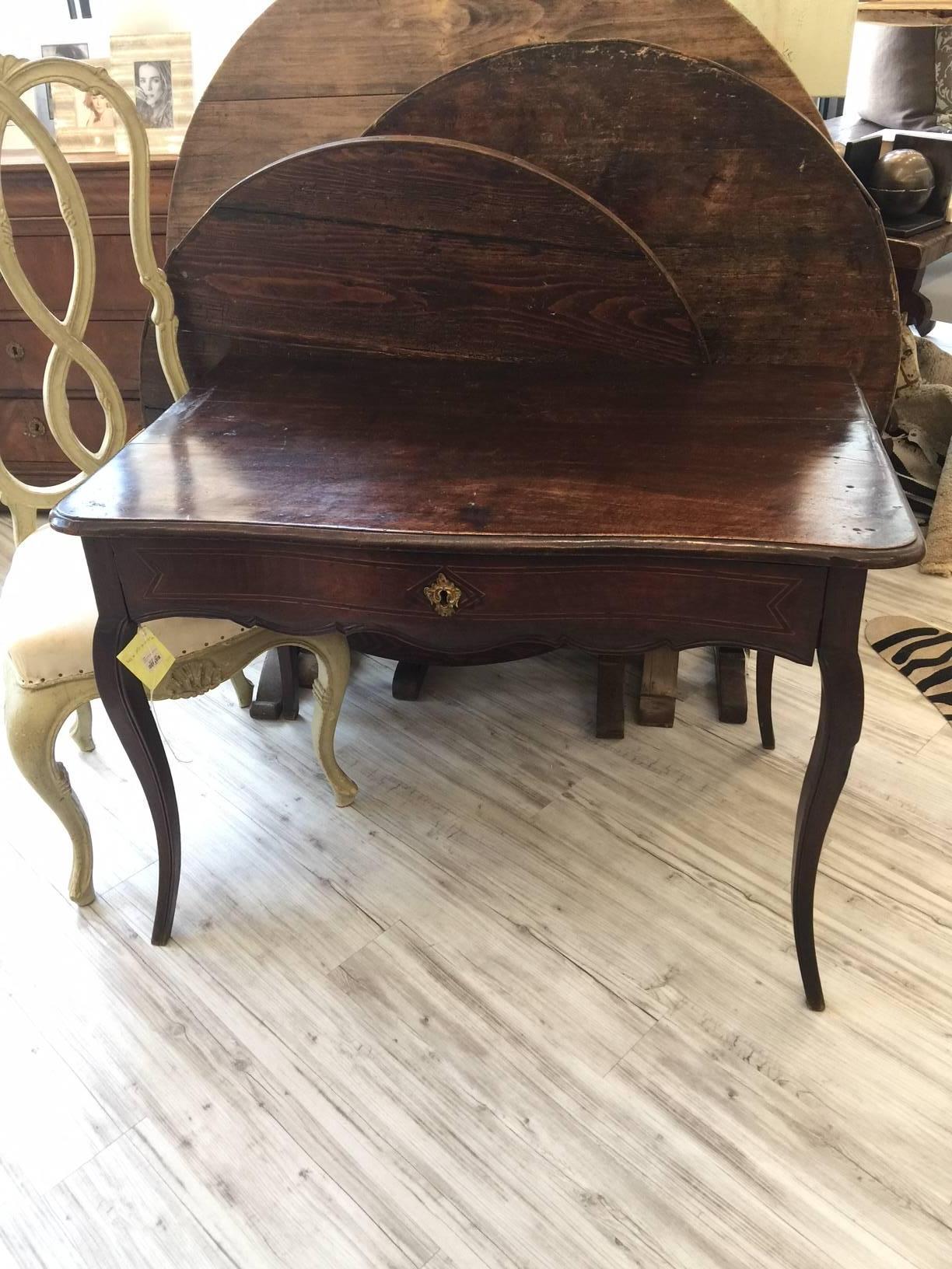 This French Louis XV style walnut side table, circa 1830 features a serpentine top over a long single dovetailed drawer. A timeless beauty, we love how this side table gives a flirty edge to a Classic look. An ornate and gilded Rococo style