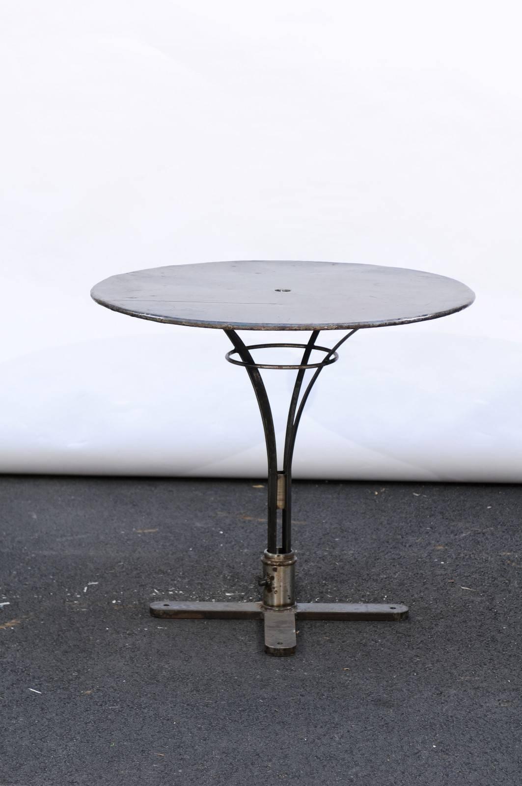 A French 20th century round iron bistrot table with pedestal base. Originally blue, this French iron side table came from a restaurant in the Loire Valley and has since been completely scraped and peeled down to reveal a beautiful brown exterior.