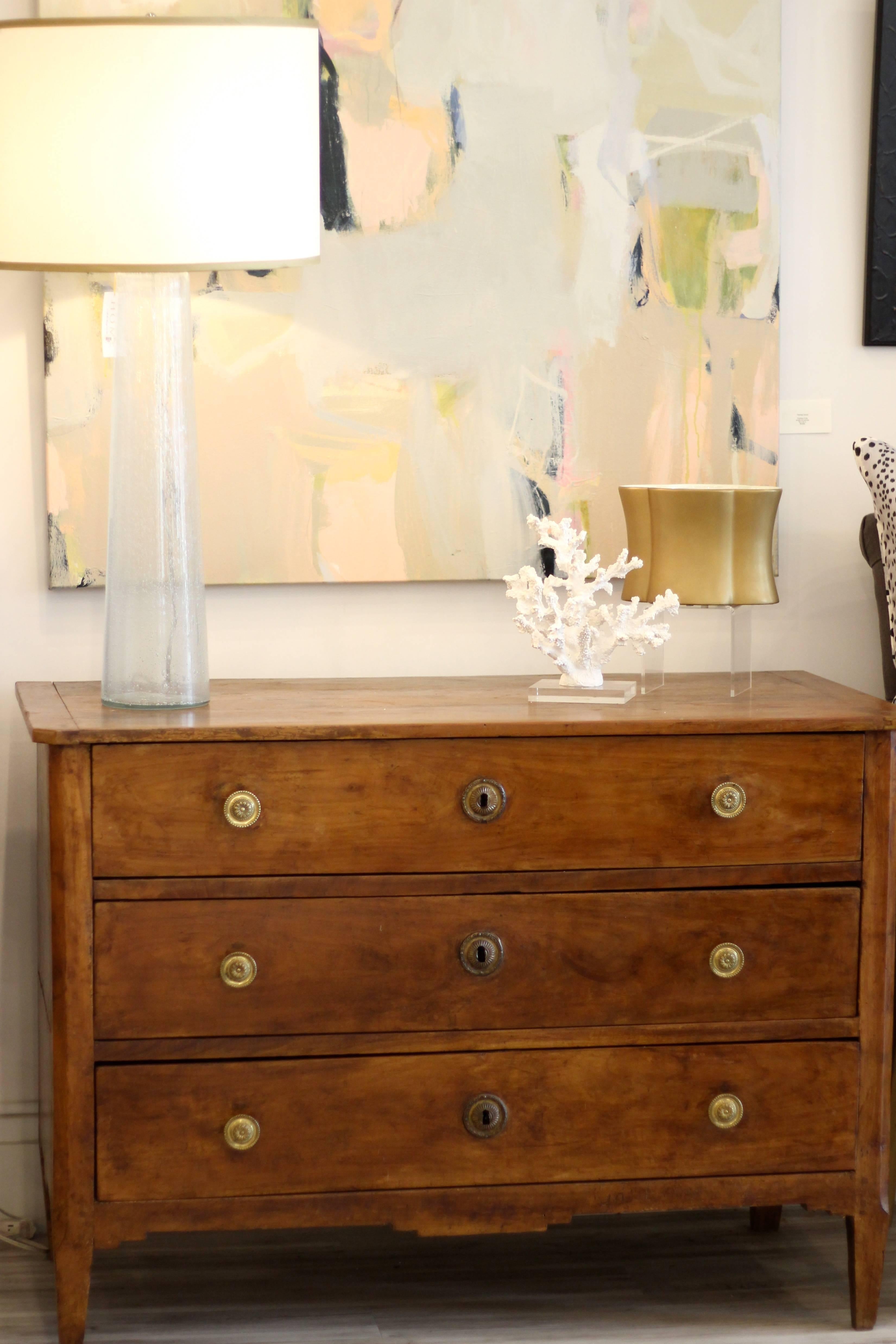 This French Louis XVI wild cherry butler's desk from the mid-19th century features a rectangular top with canted sides in the front over three drawers. This French piece, called a Butler's desk, is a combination of desk and chest of drawers. The