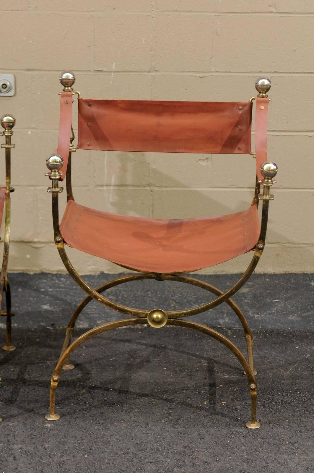 A French Regency Campaign Curule (also known as Savonarola) chair from the mid-20th century with leather back, arms, seat and a brass body on a half-moon X-shaped base. This elegant leather and brass Curule chair caught our eye. Heavy and