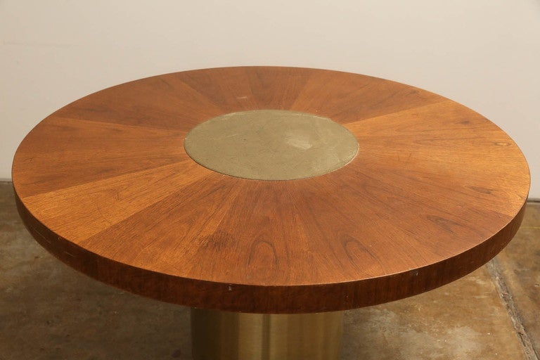 Offered is a mid-century modern circular walnut table top with center brass inlay paired with a brushed brass and wood pedestal bottom.  This versatile piece could be used as a dining, breakfast, game, small conference or center foyer table.