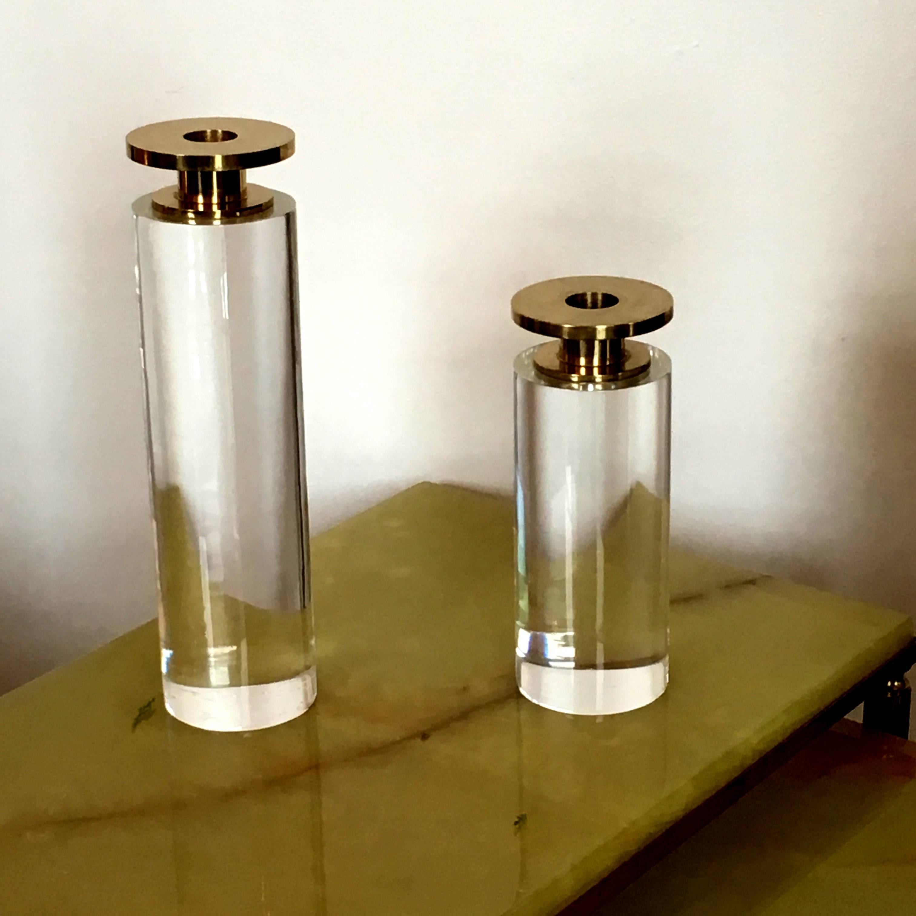 Offered are a very sleek and trendy pair of vintage modern Lucite and brass candleholders. This luxe pair would look fabulous with just about any decor. The Large candleholder is 10